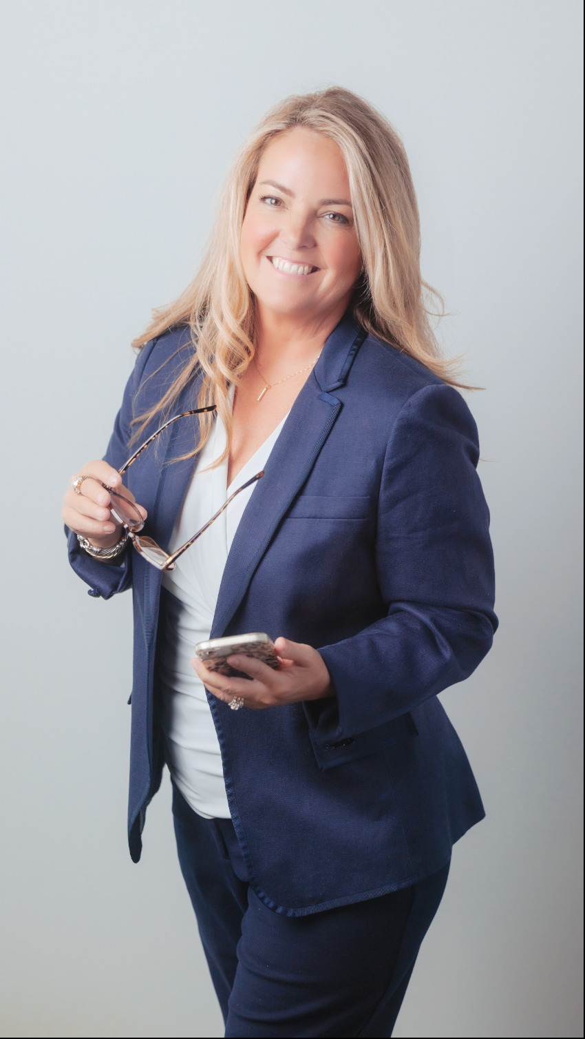 Southern Maine Brand Photographer - Professional in navy blazer and white top holding phone and glasses against grey background.