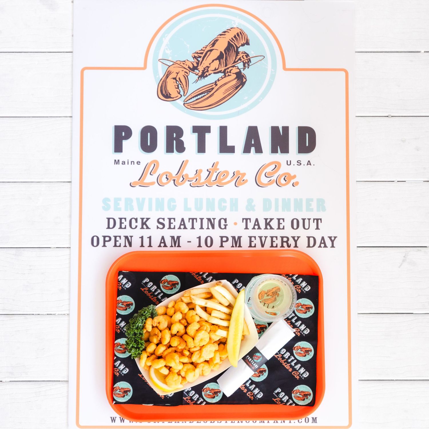Portland Lobster Co. Maine USA sign with lunch and dinner menu, deck seating, takeout, open 11AM-10PM daily.