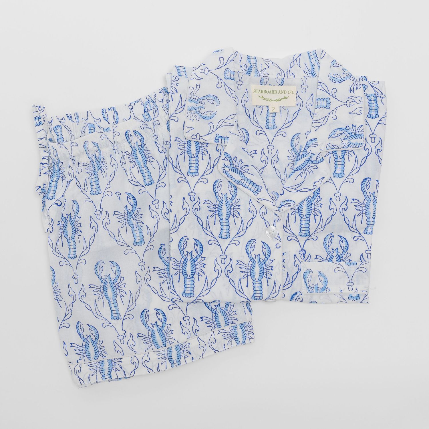 Blue and white lobster print pajama set with short sleeve top and shorts, featuring elegant damask-style pattern.