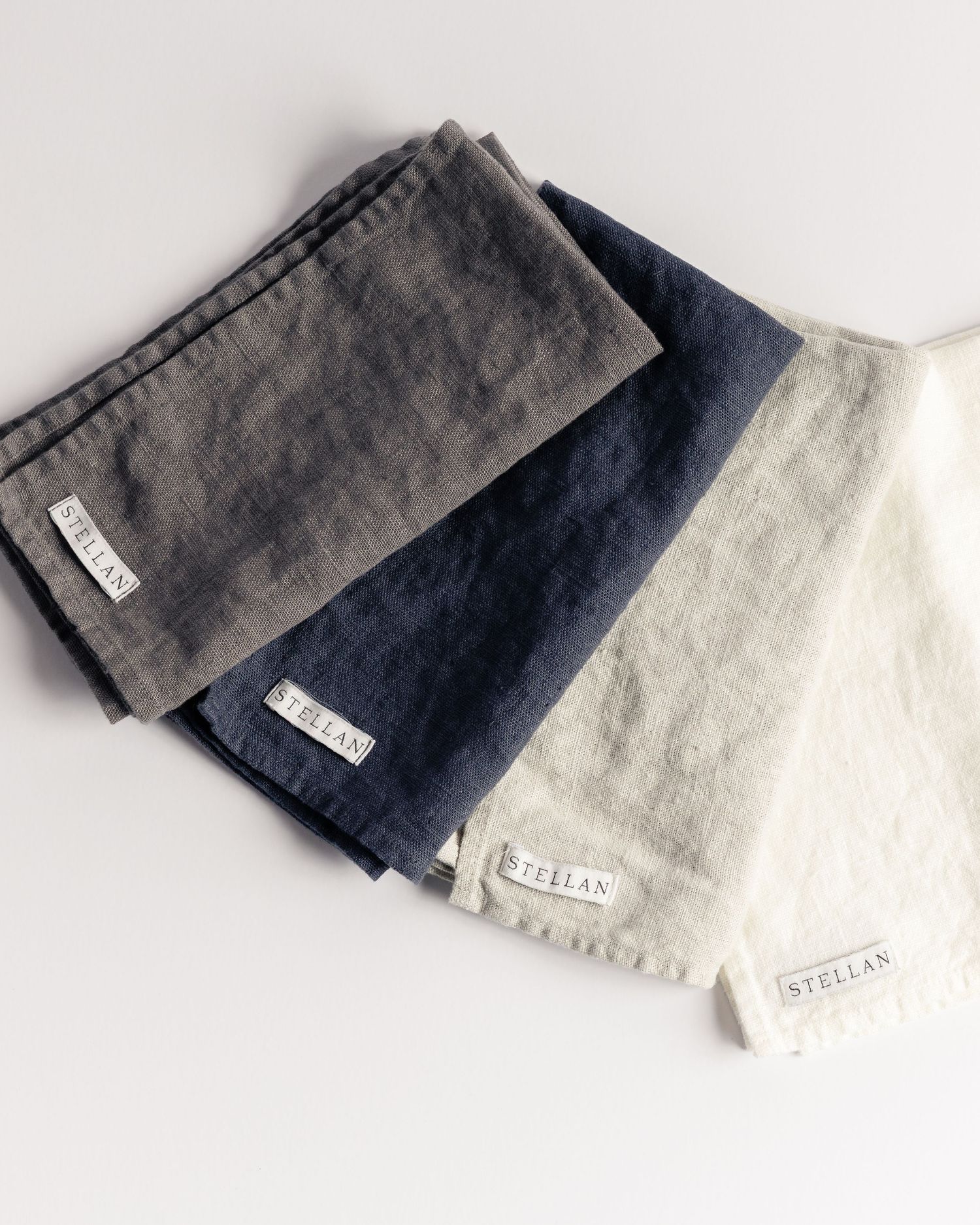 Linen napkins in gray, navy, and natural white with Stellan labels, product photography by Portland Maine photographer Ang Foley