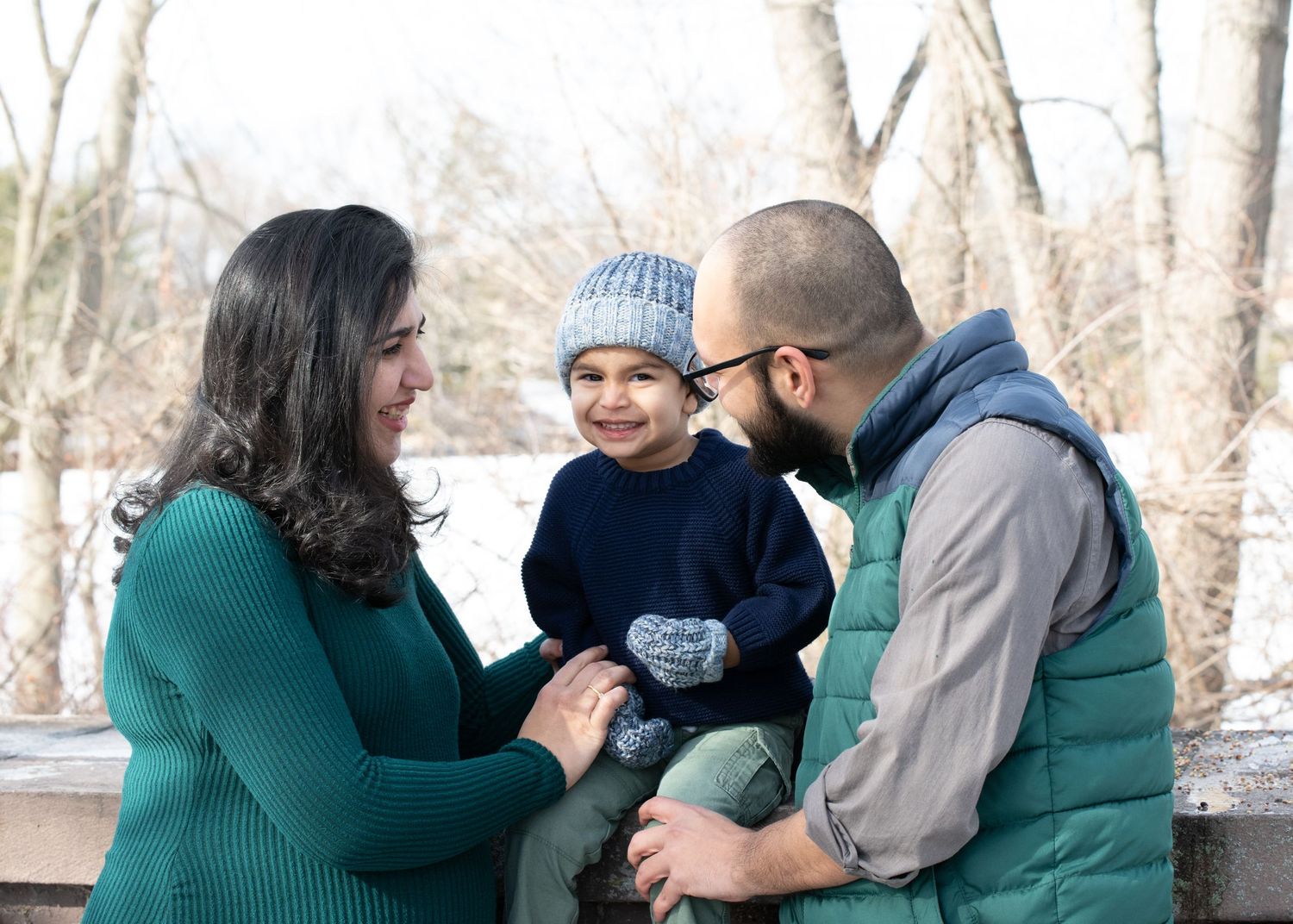 Family shares tender moment together during winter outdoor photoshoot.