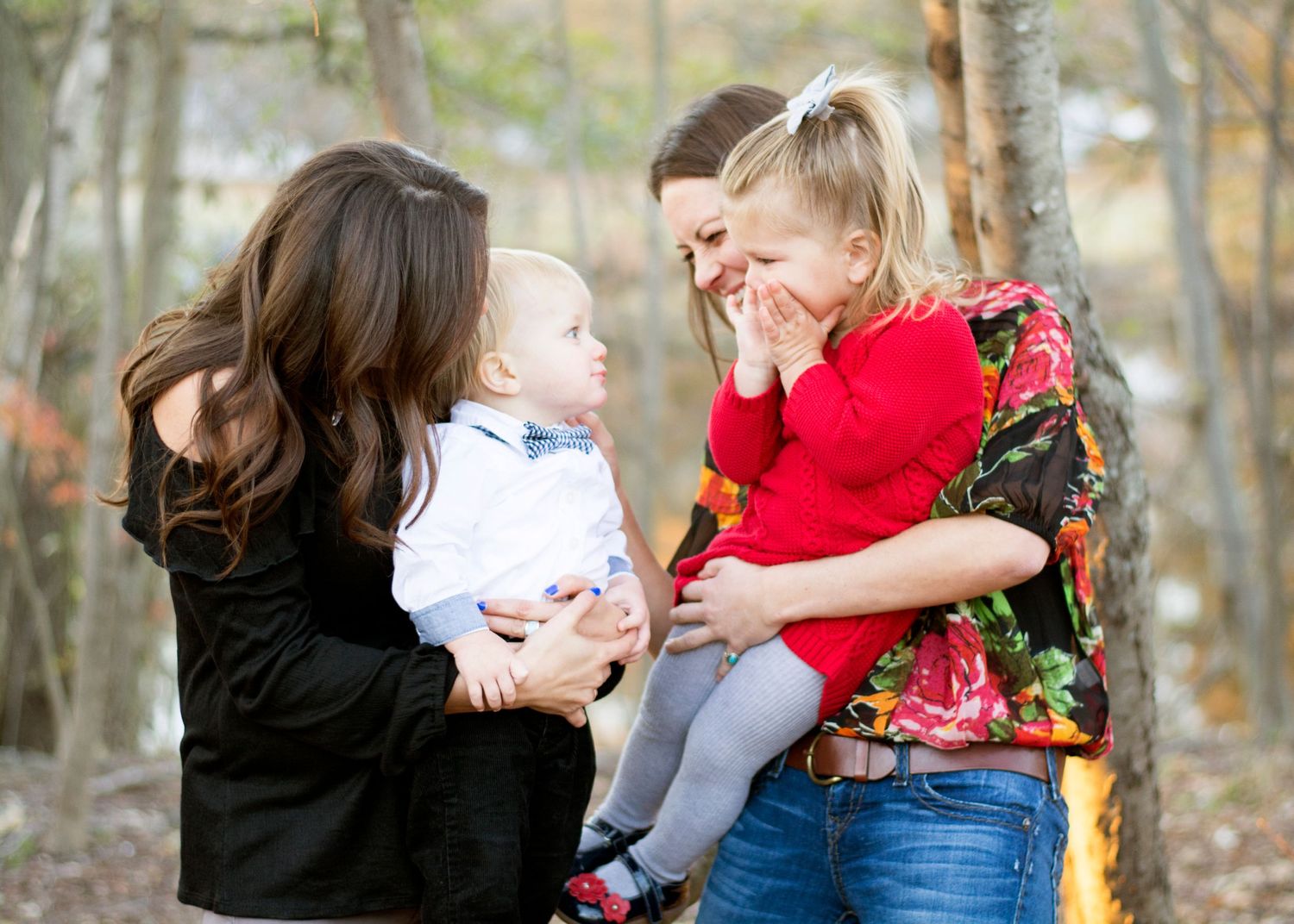 A cheerful group shares laughter while posing together outdoors in natural light.