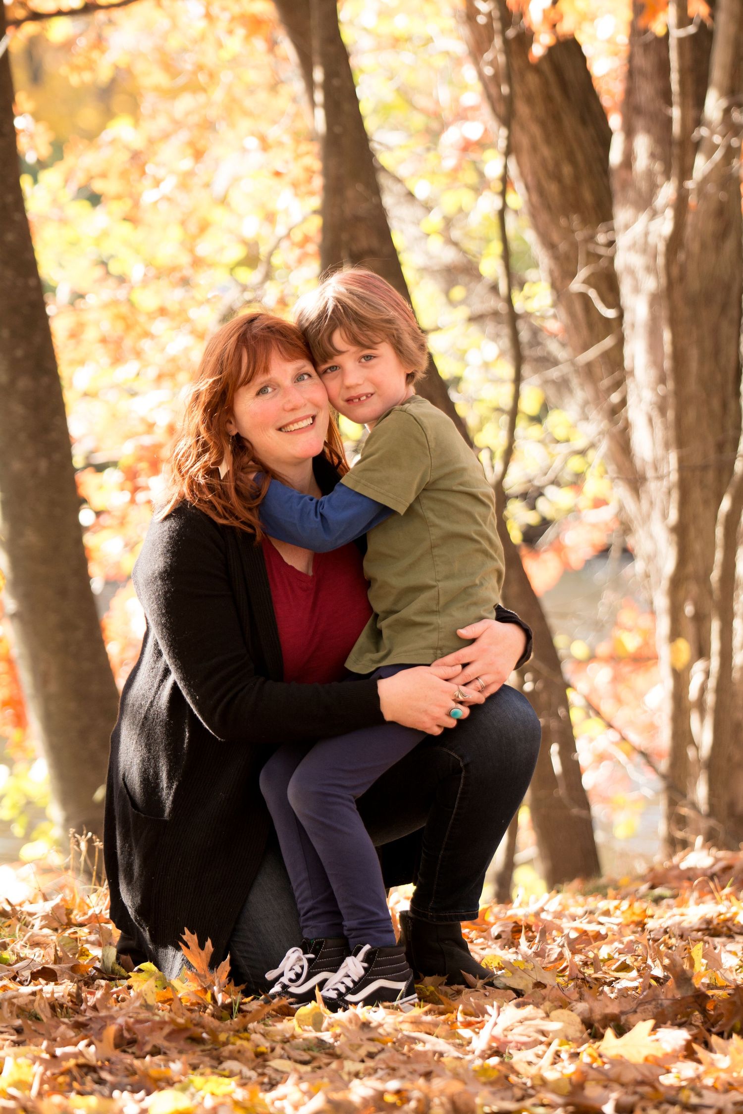 A warm autumn portrait showing affection among fallen leaves in the woods.