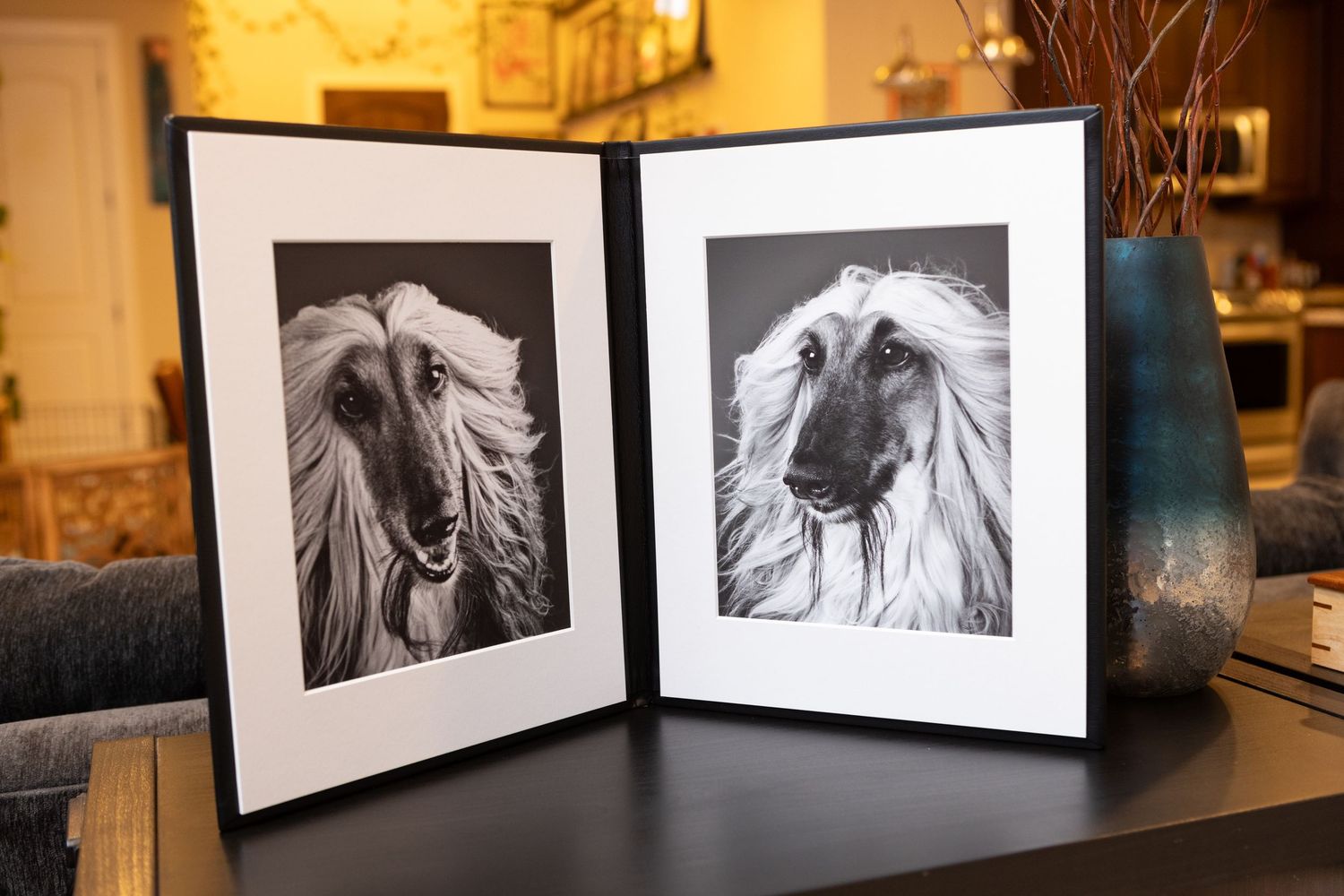 A folio displaying two Afghan hounds sits on a table.