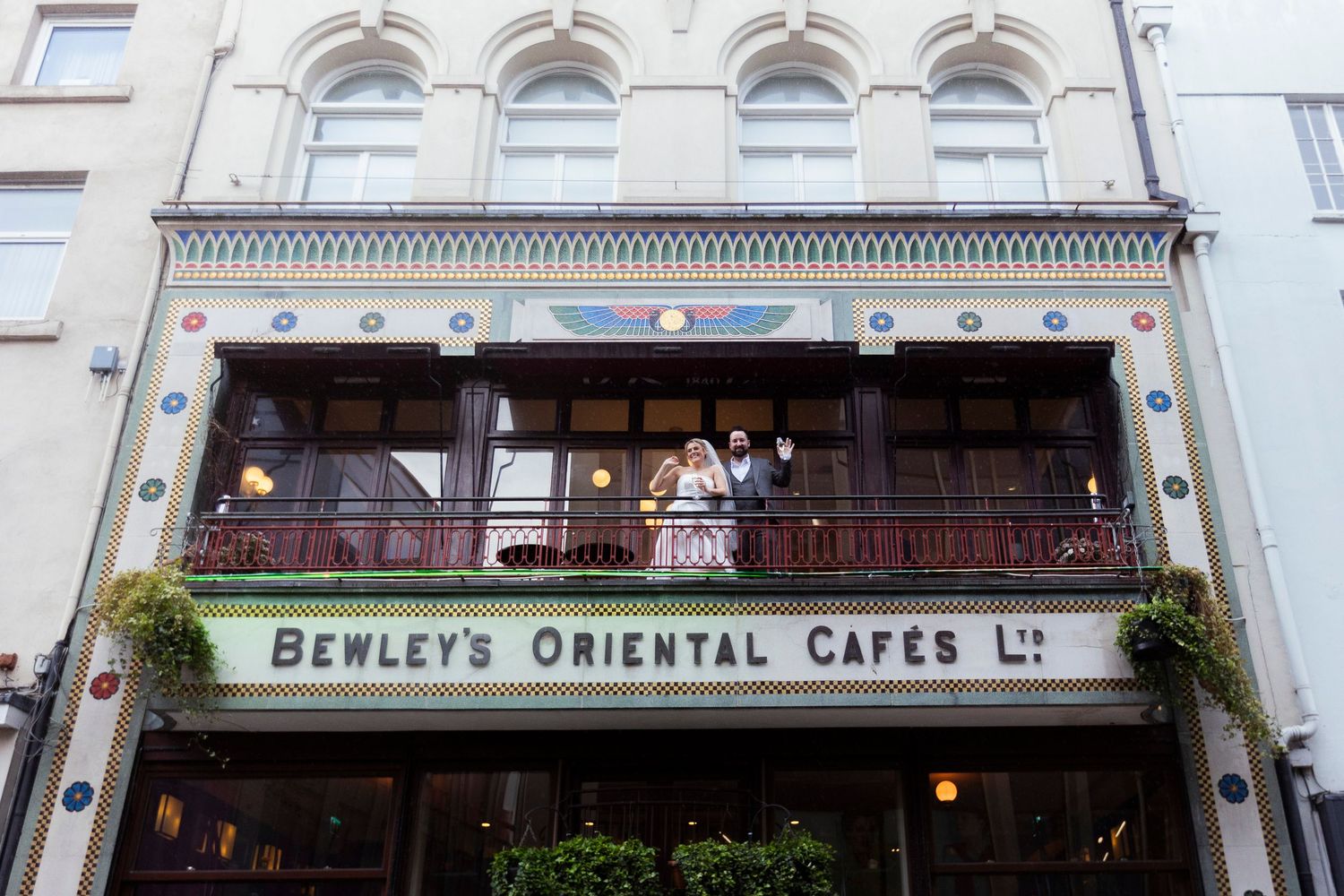 Bewley's Oriental Cafes Ltd. storefront with ornate facade and people on the balcony in Dublin, Ireland.