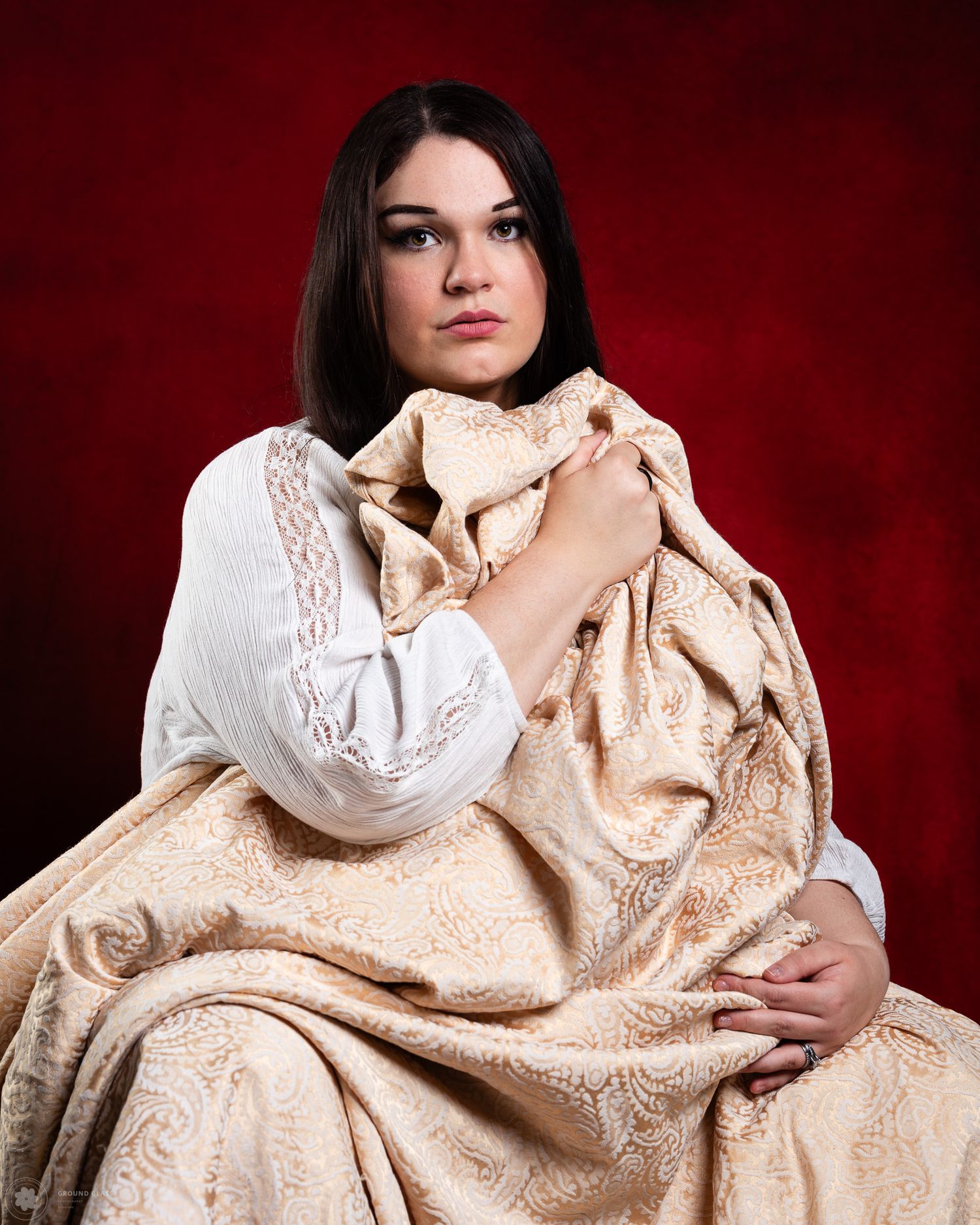 Editorial portrait of a woman in cream fabric against a deep red background — Ground Glass Photography, Kent Washington