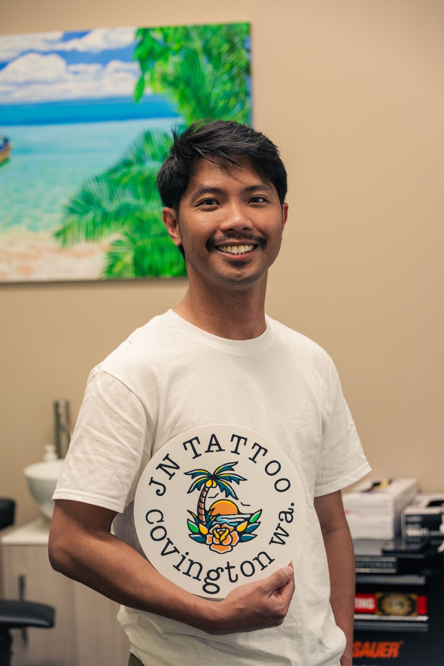 Business portrait of tattoo artist Juan Nangkil smiling in his studio — editorial photography by Ground Glass Photography, Kent WA