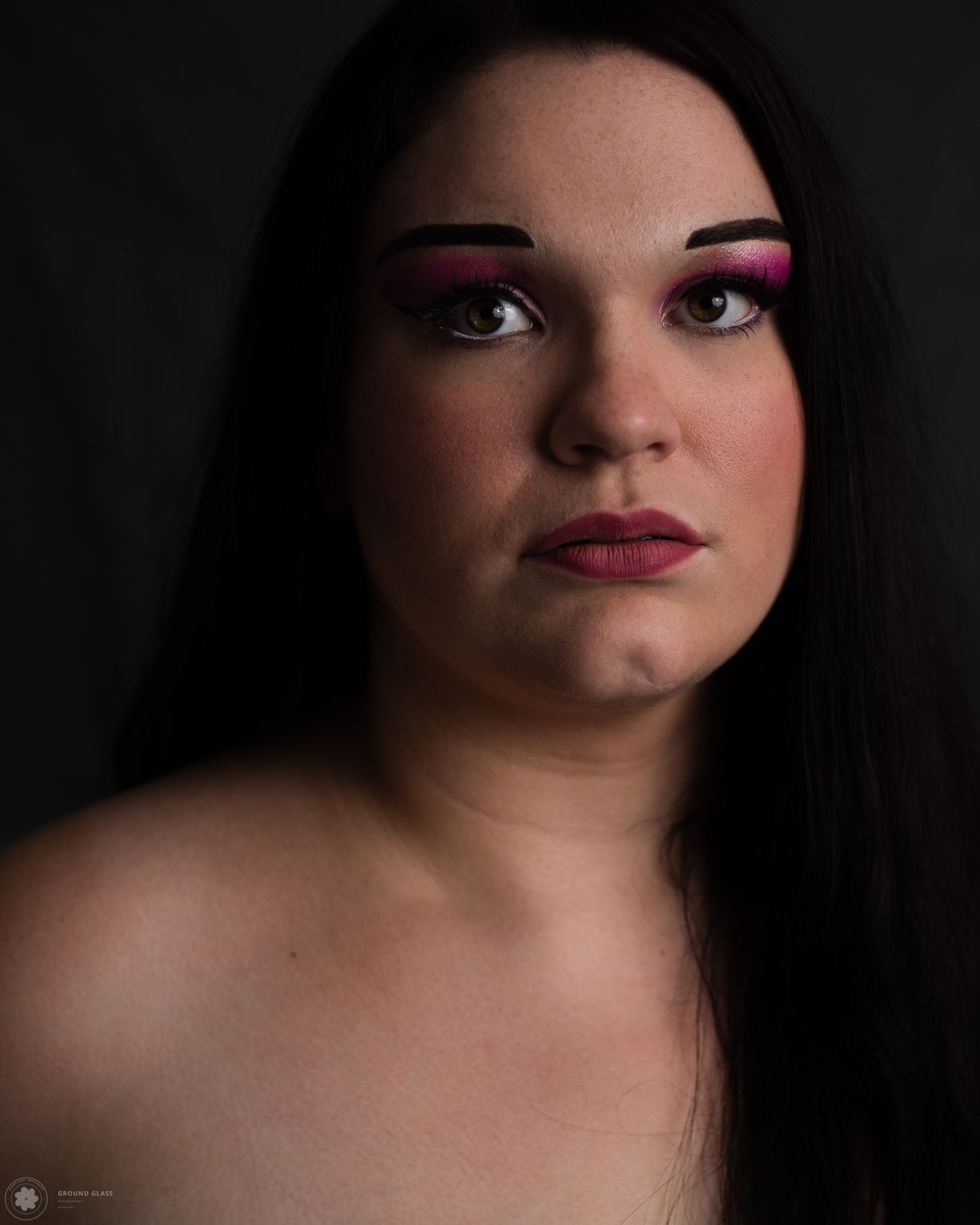 Dramatic low-key editorial portrait of a woman with dark hair in signature chiaroscuro ligh style— Ground Glass Photography, Kent Washington