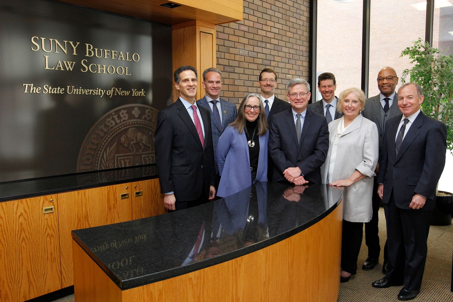 Group of professionals posing at SUNY Buffalo Law School reception desk.