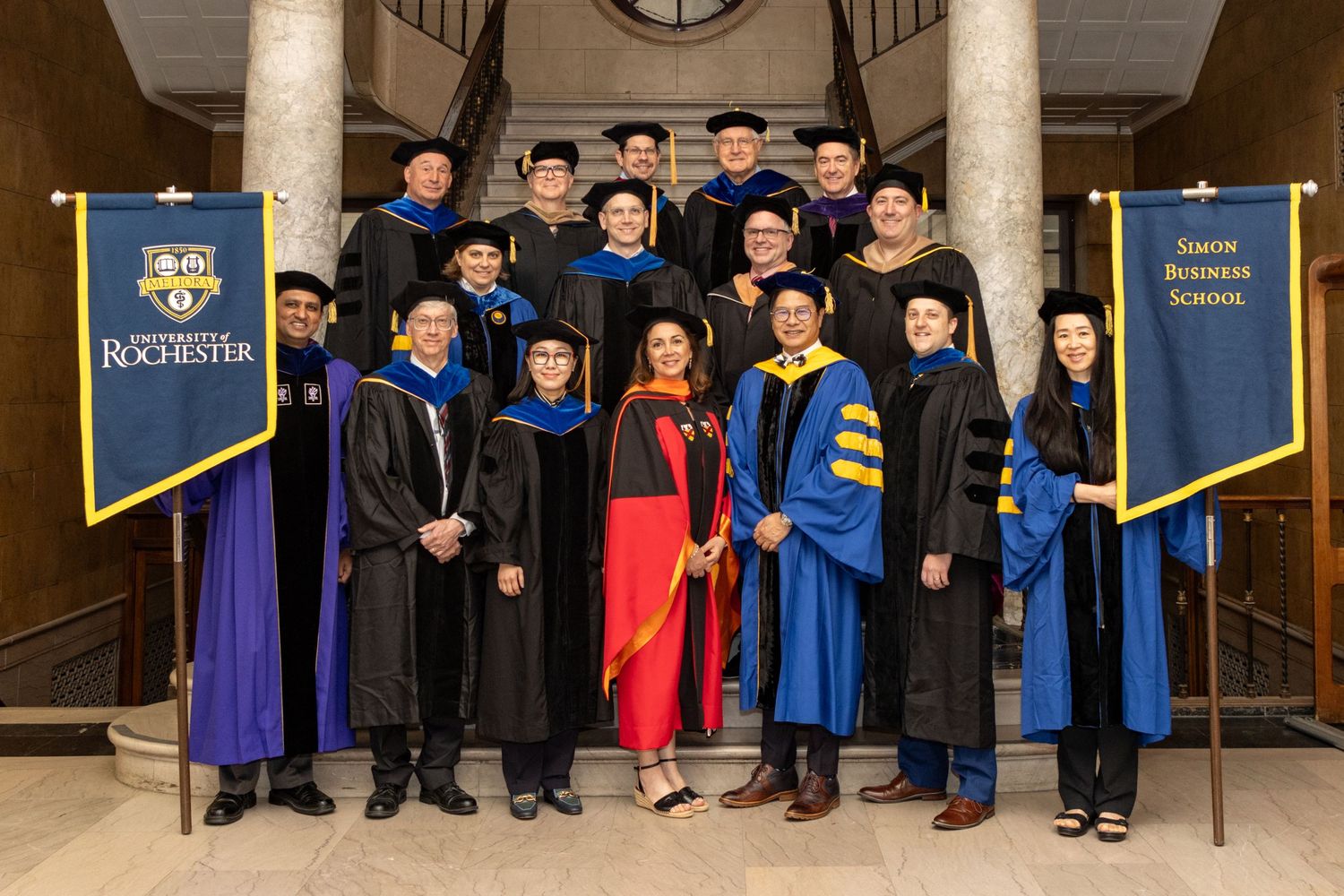 University of Rochester Simon Business School graduation group photo on stairs.