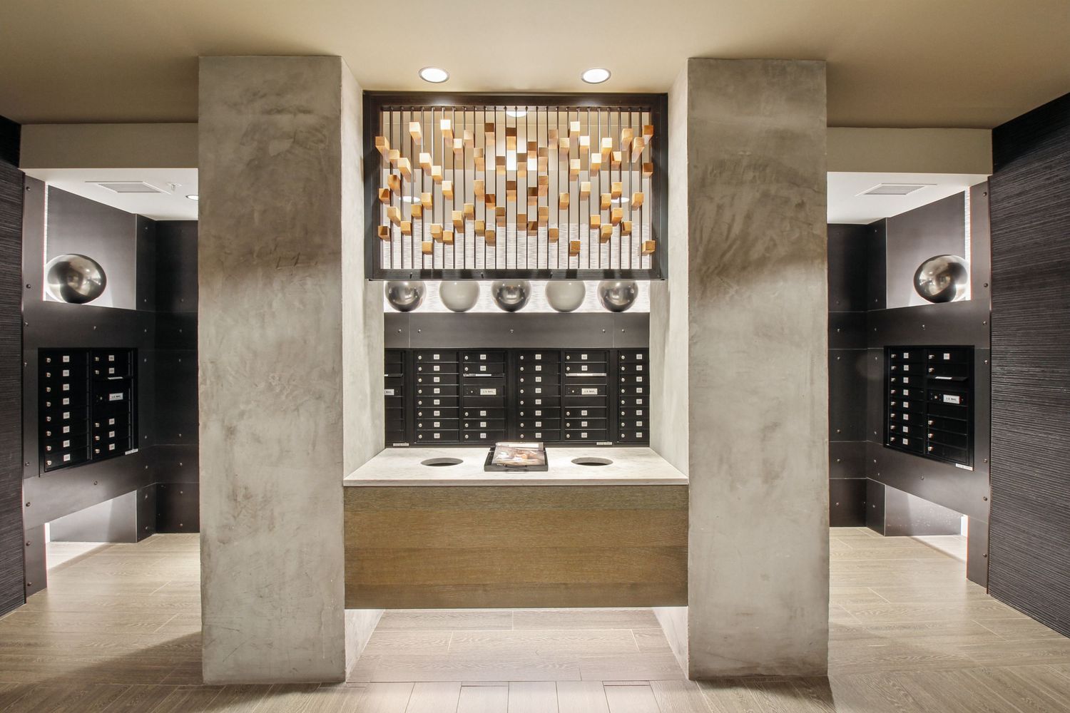 Modern apartment mailbox area with decorative mosaic tile accent and concrete columns.