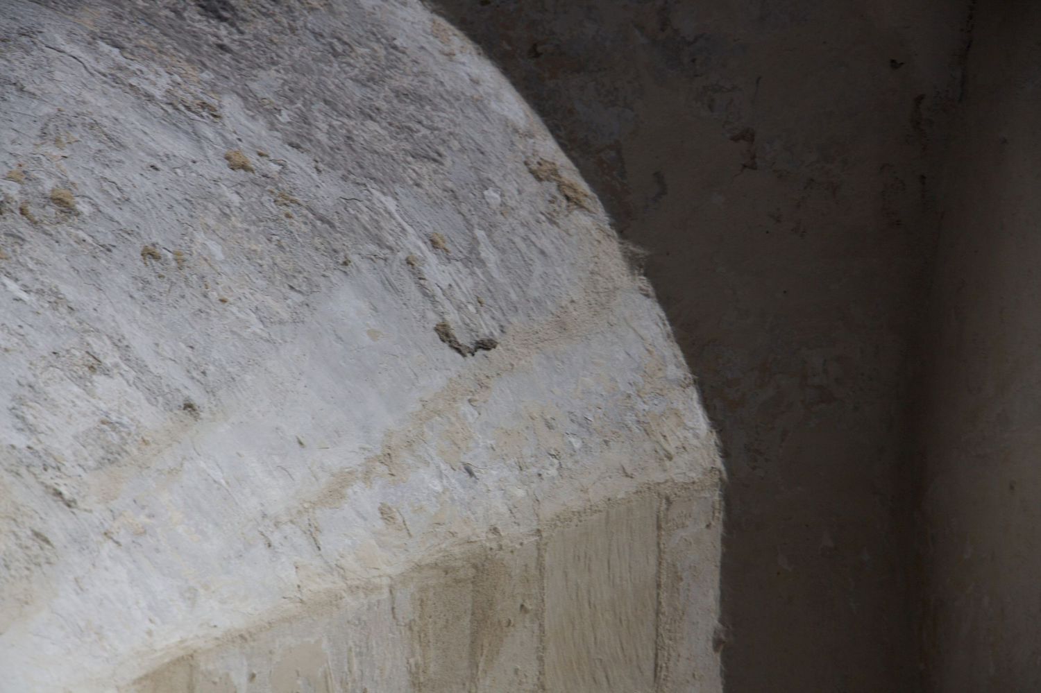 Close-up detail of rough-hewn limestone arch blocks in an ancient stone building interior.