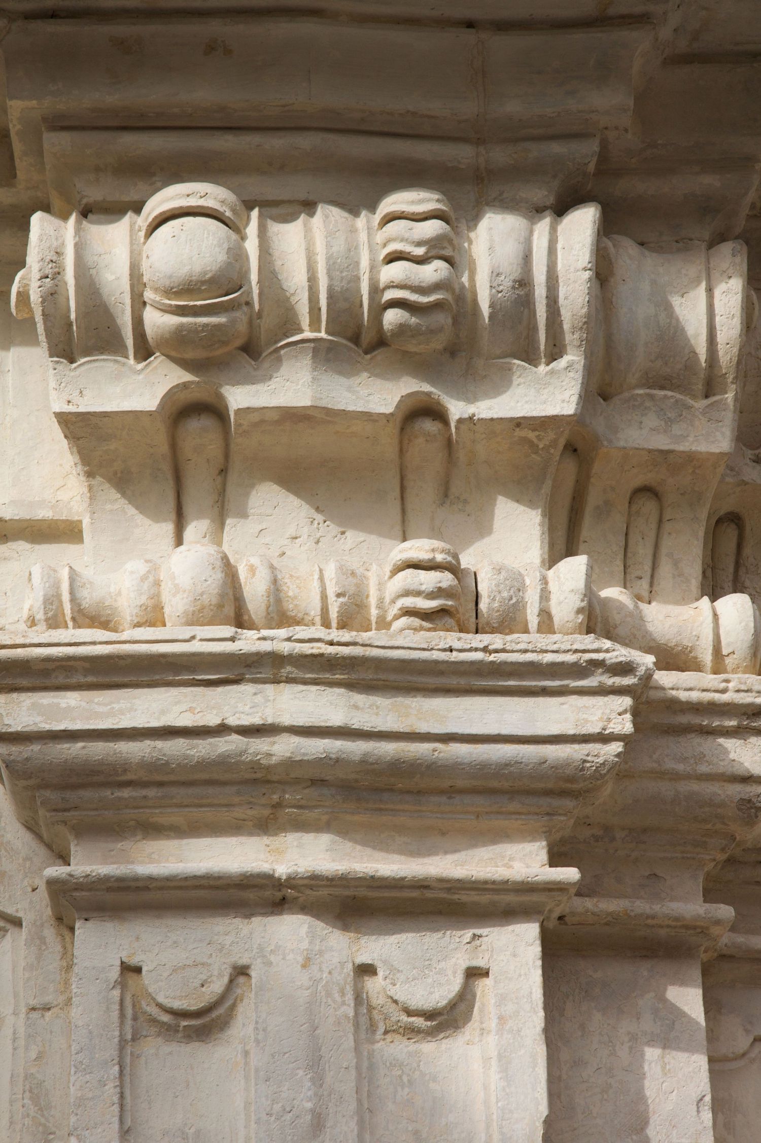 Intricate carved stone architectural details featuring ornate scrolls and decorative moldings on a classical building.