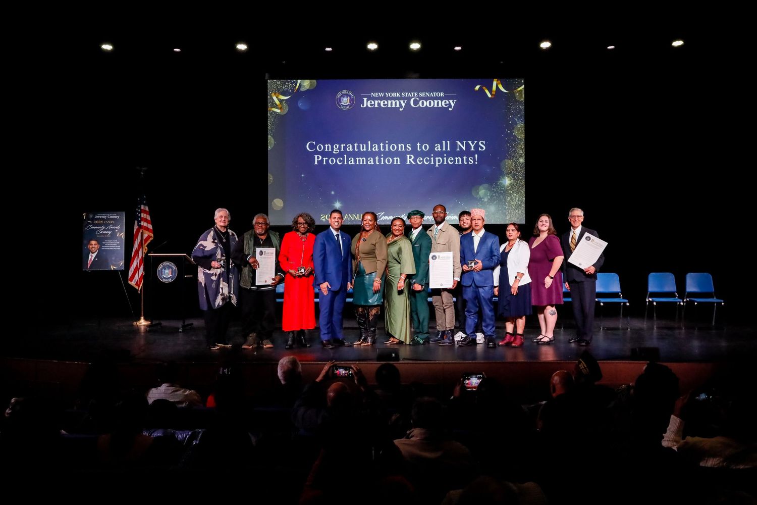 Group of NYS Proclamation recipients on stage at a Jeremy Cooney event celebrating their achievements.