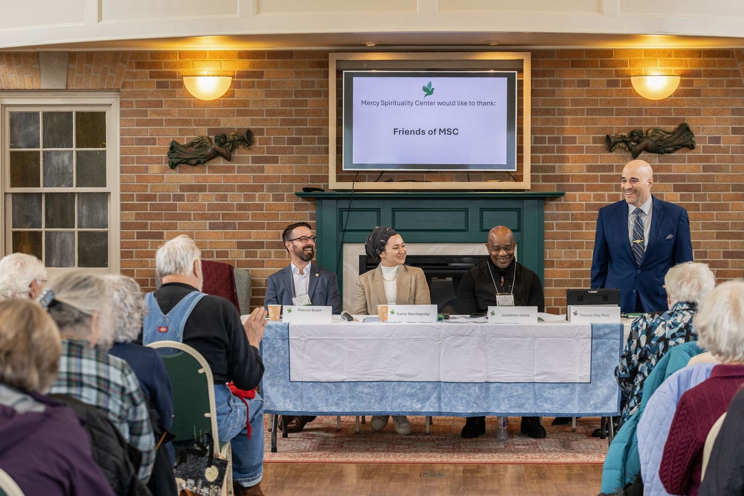Panel discussion at Friends of MBQ meeting with speakers at table addressing seated audience.