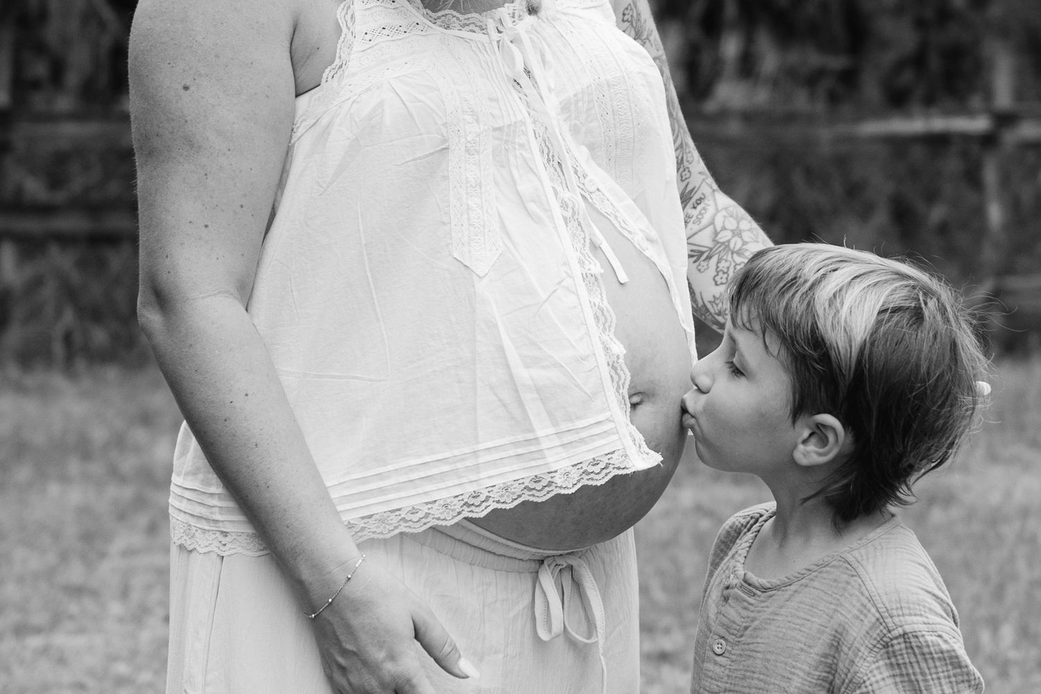 A timeless natural photo of a son kissing his mother's pregnant belly in Palm Beach FL.