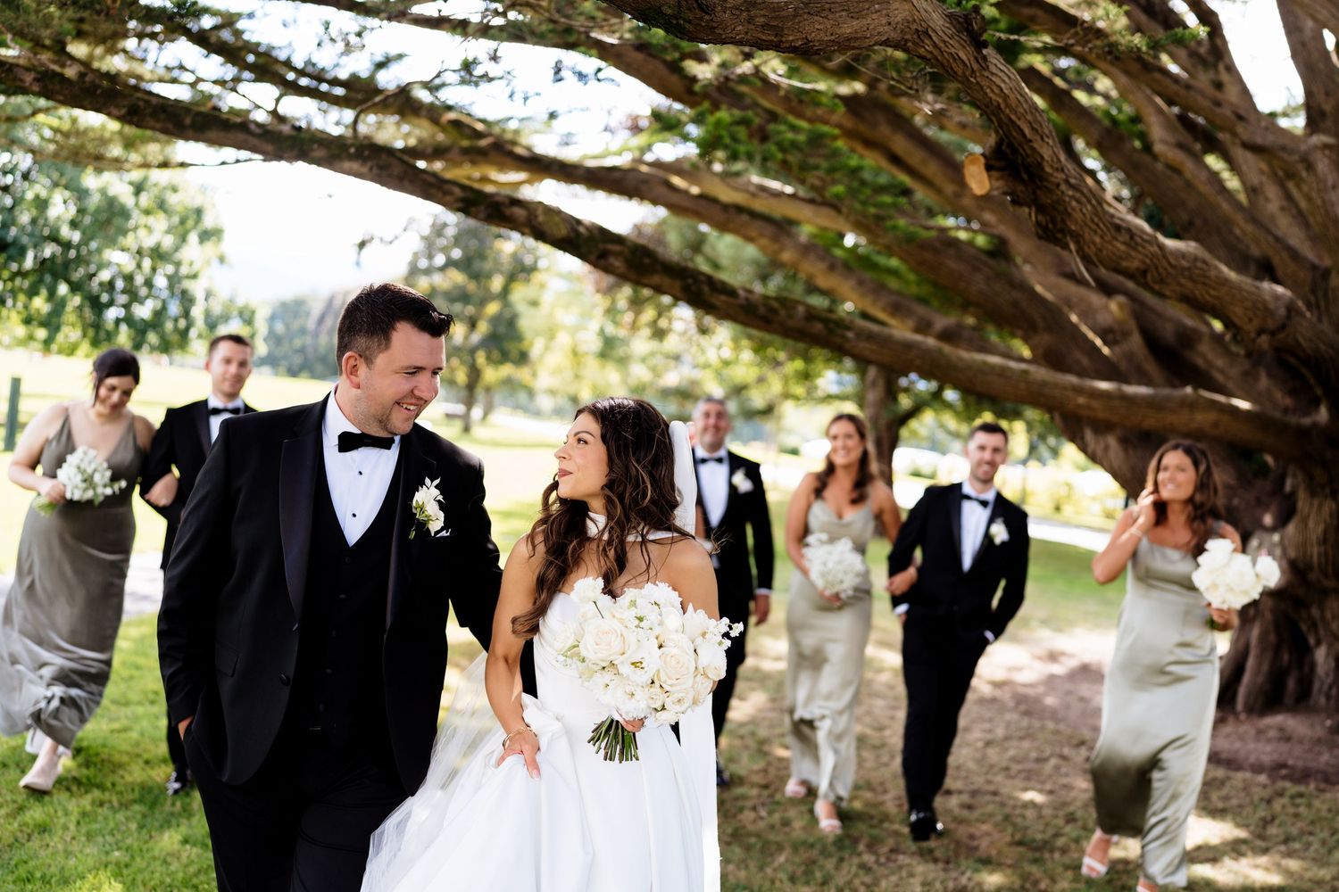 Newlywed couple shares romantic moments in an outdoor garden setting during their wedding celebration.