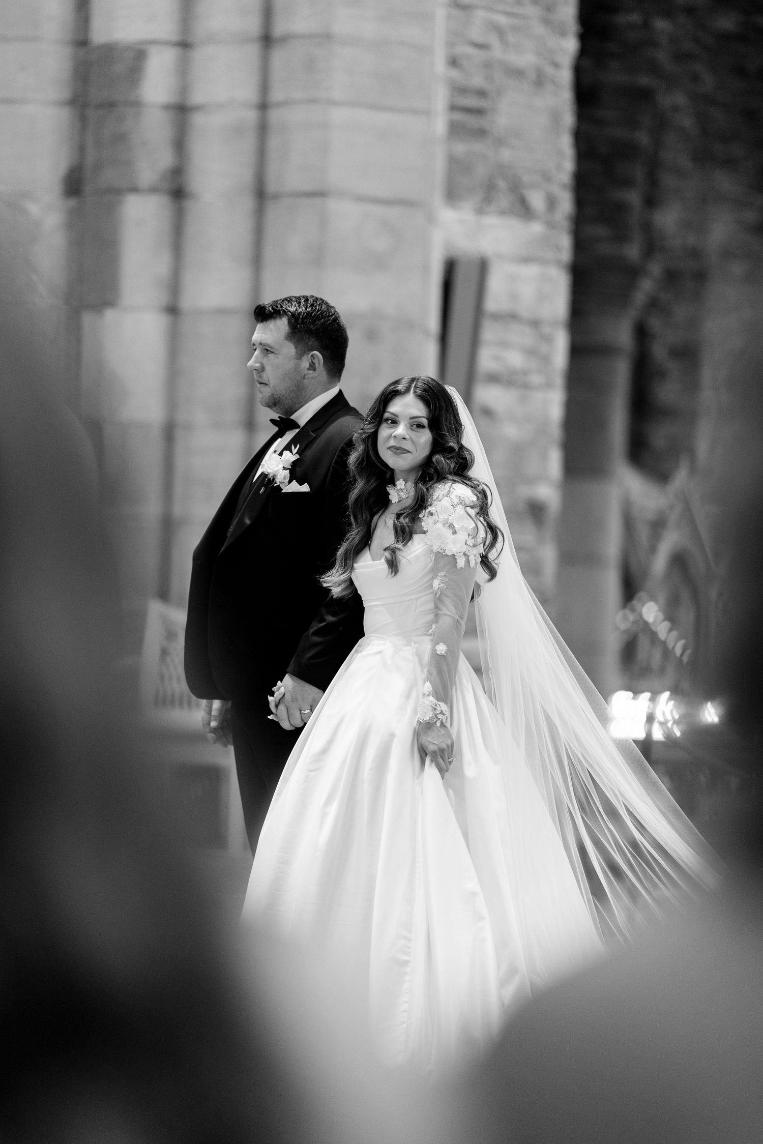 A series of black and white wedding photos showing the bride in a flowing white dress captured in candid moments.