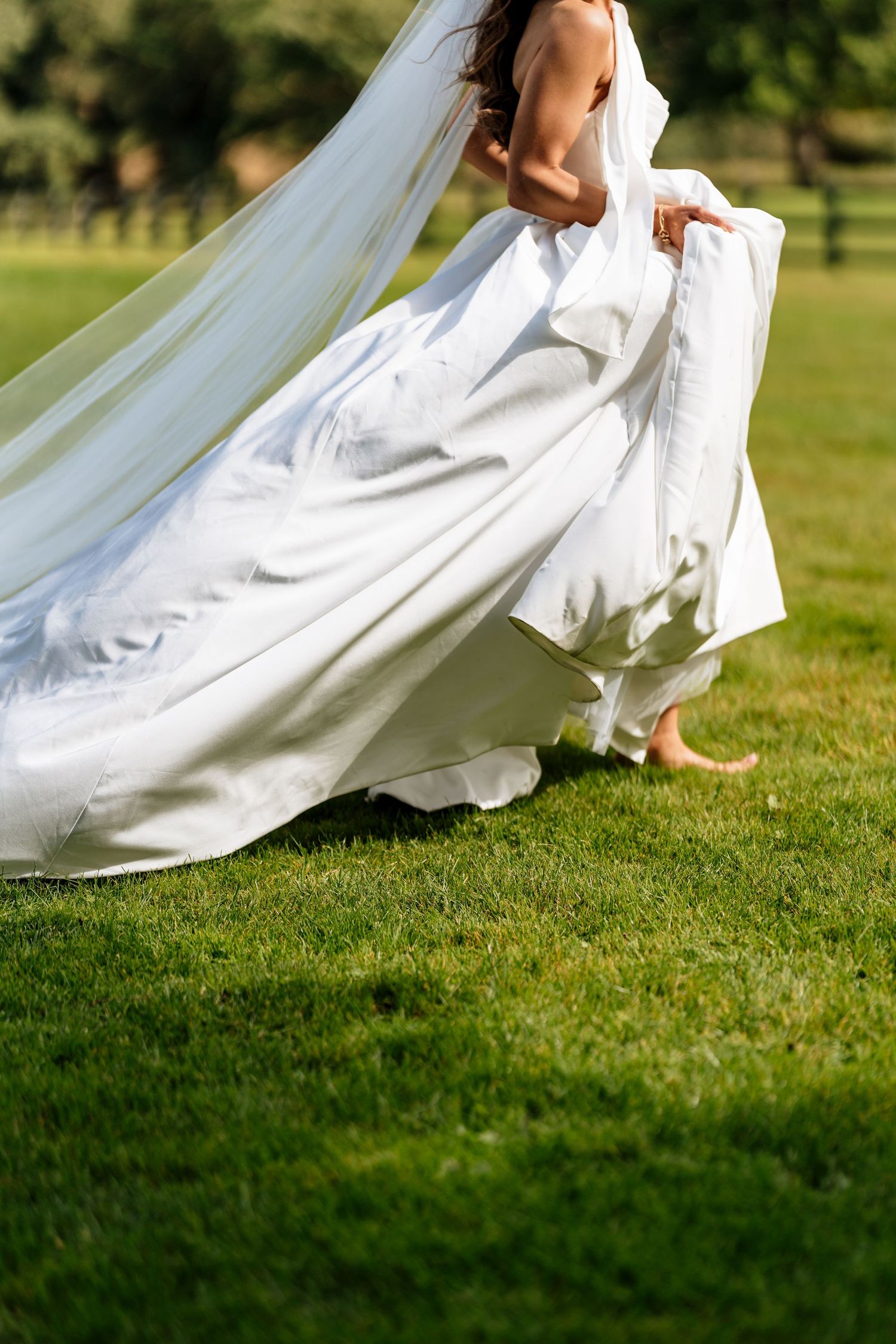 Close-up series of flowing white wedding dress fabric moving gracefully over green grass in an outdoor setting.