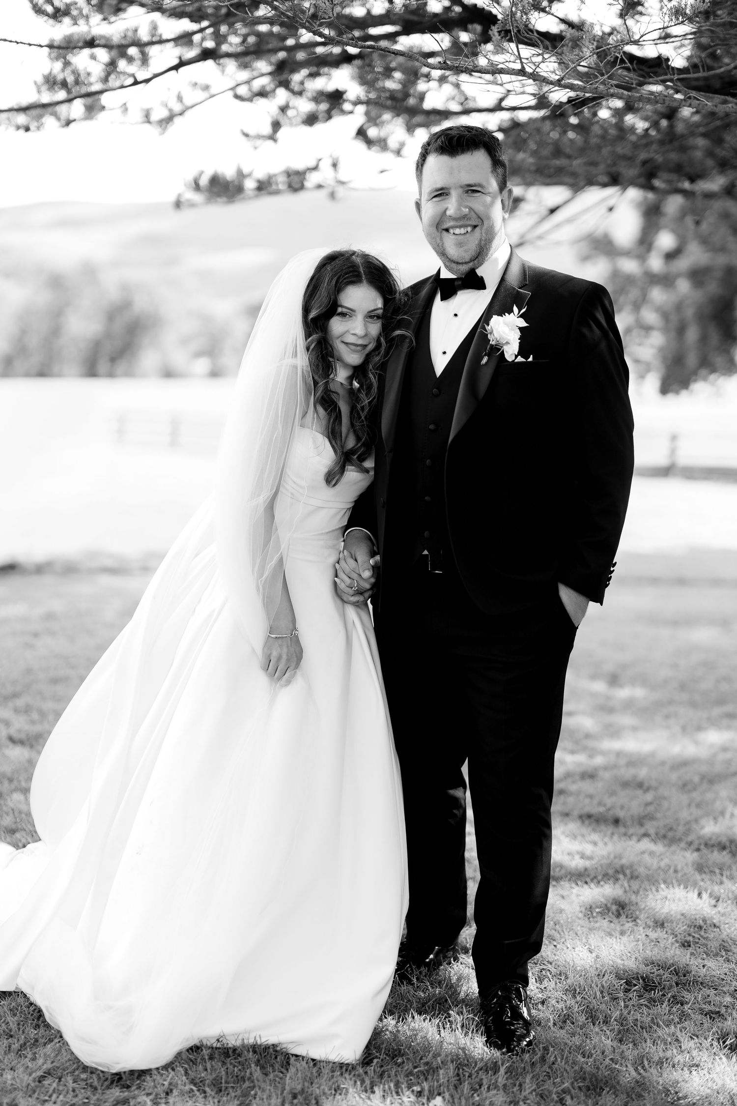 A black and white wedding photo montage showing candid moments between a couple outdoors in formal attire.