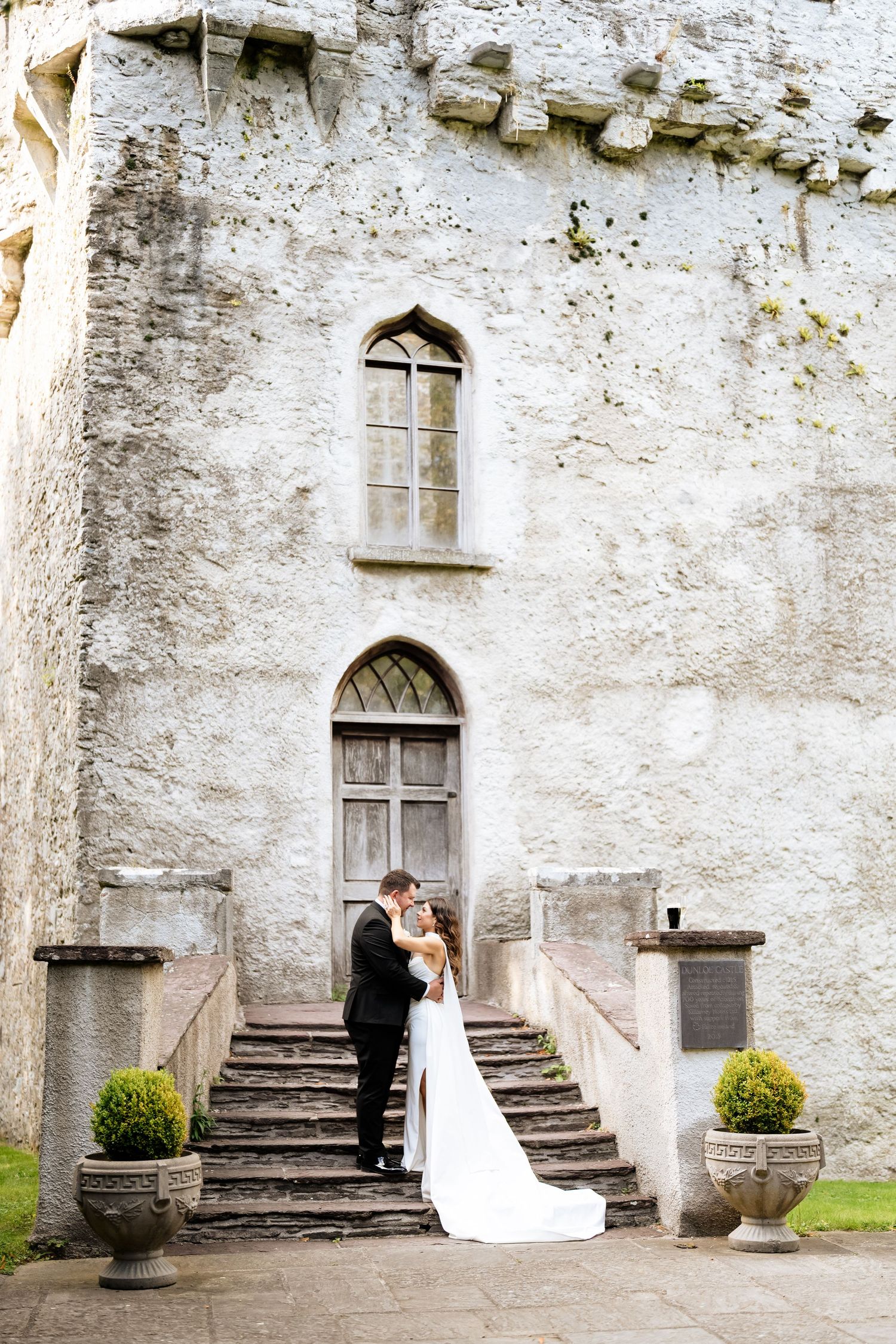 Wedding couple poses on elegant stone staircase at historic castle entrance in romantic sequence of photos.