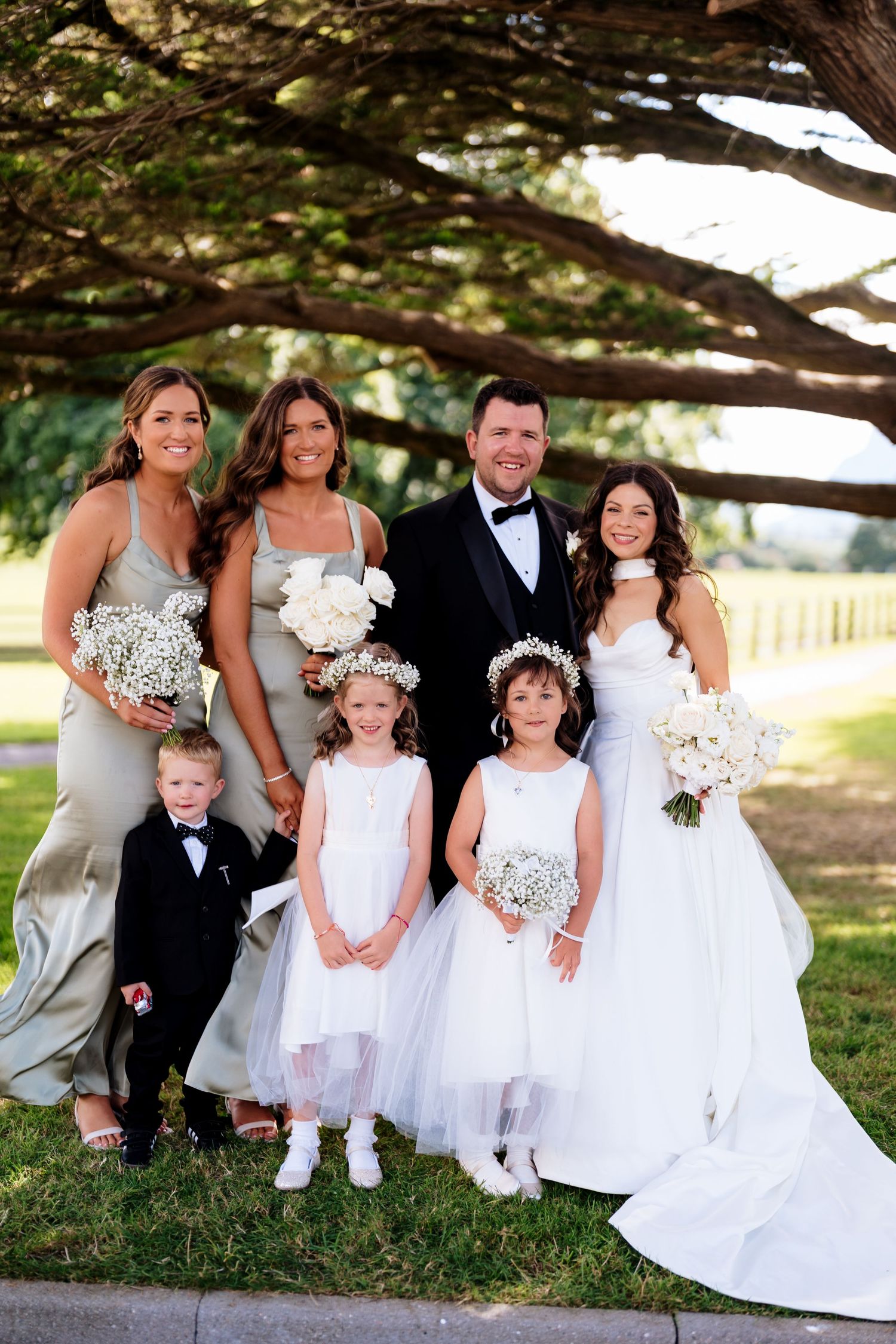 Sequence of outdoor wedding photos with a bride, groom and flower girls in white dresses under a shady tree.