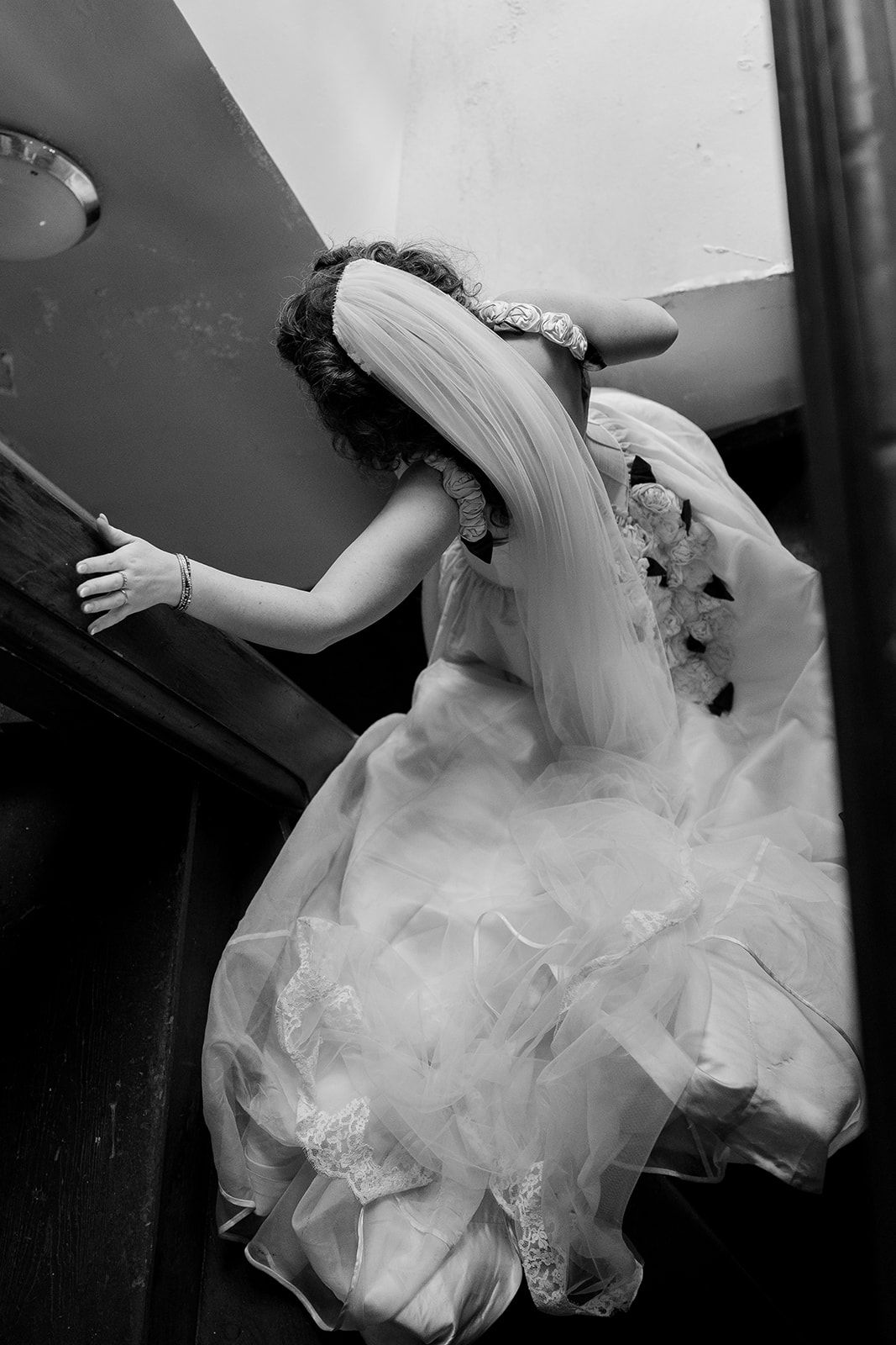 A black and white artistic photo series showing flowing movement of a white wedding dress against a dark background.