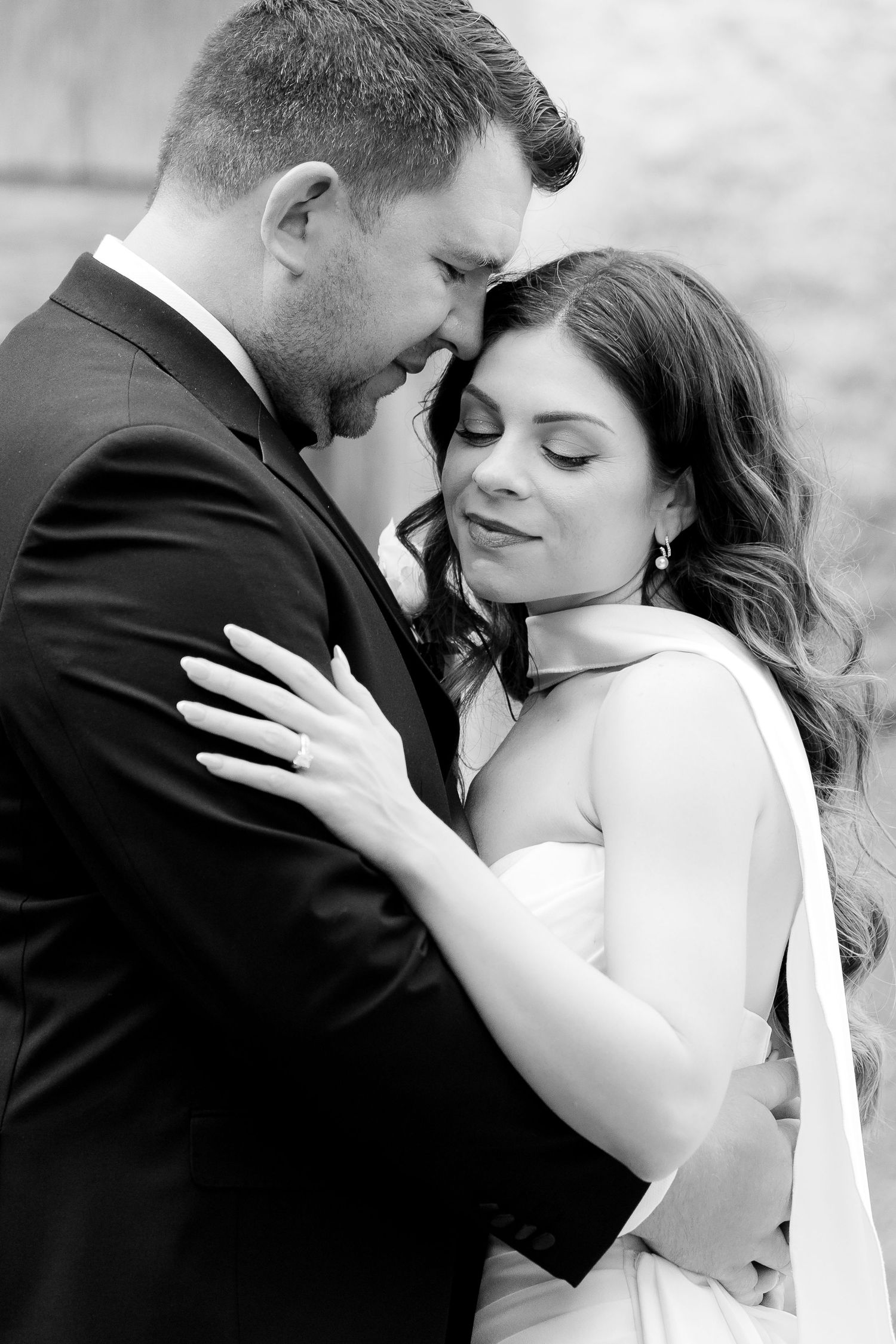 A series of romantic black and white wedding photos showing tender moments between newlyweds.