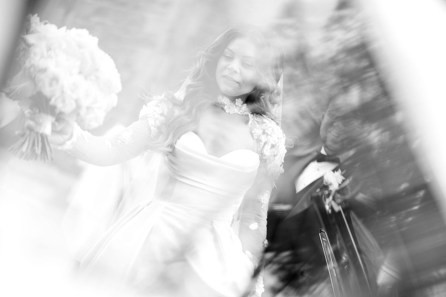 Blurry black and white artistic photograph showing abstract motion and silhouettes in a dreamy composition.
