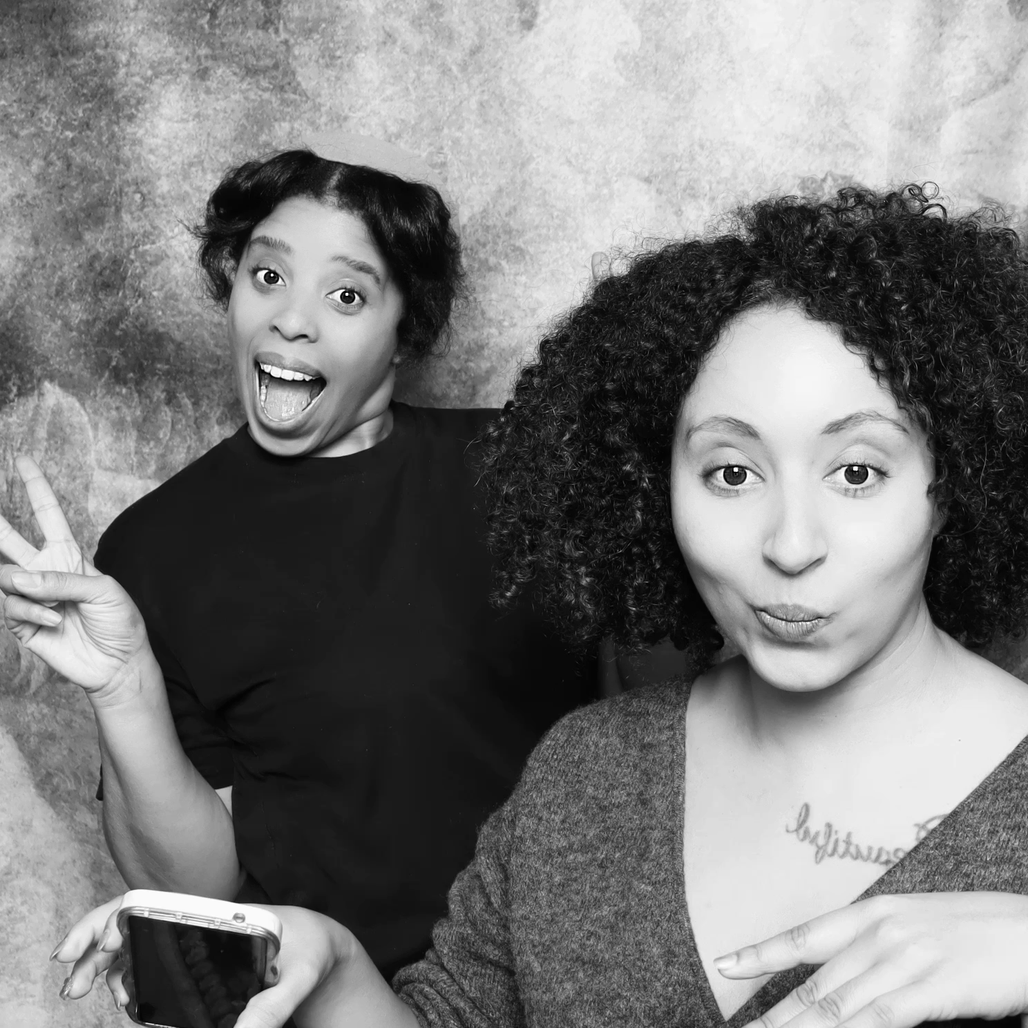A black and white animated GIF featuring two women smiling and making silly faces.