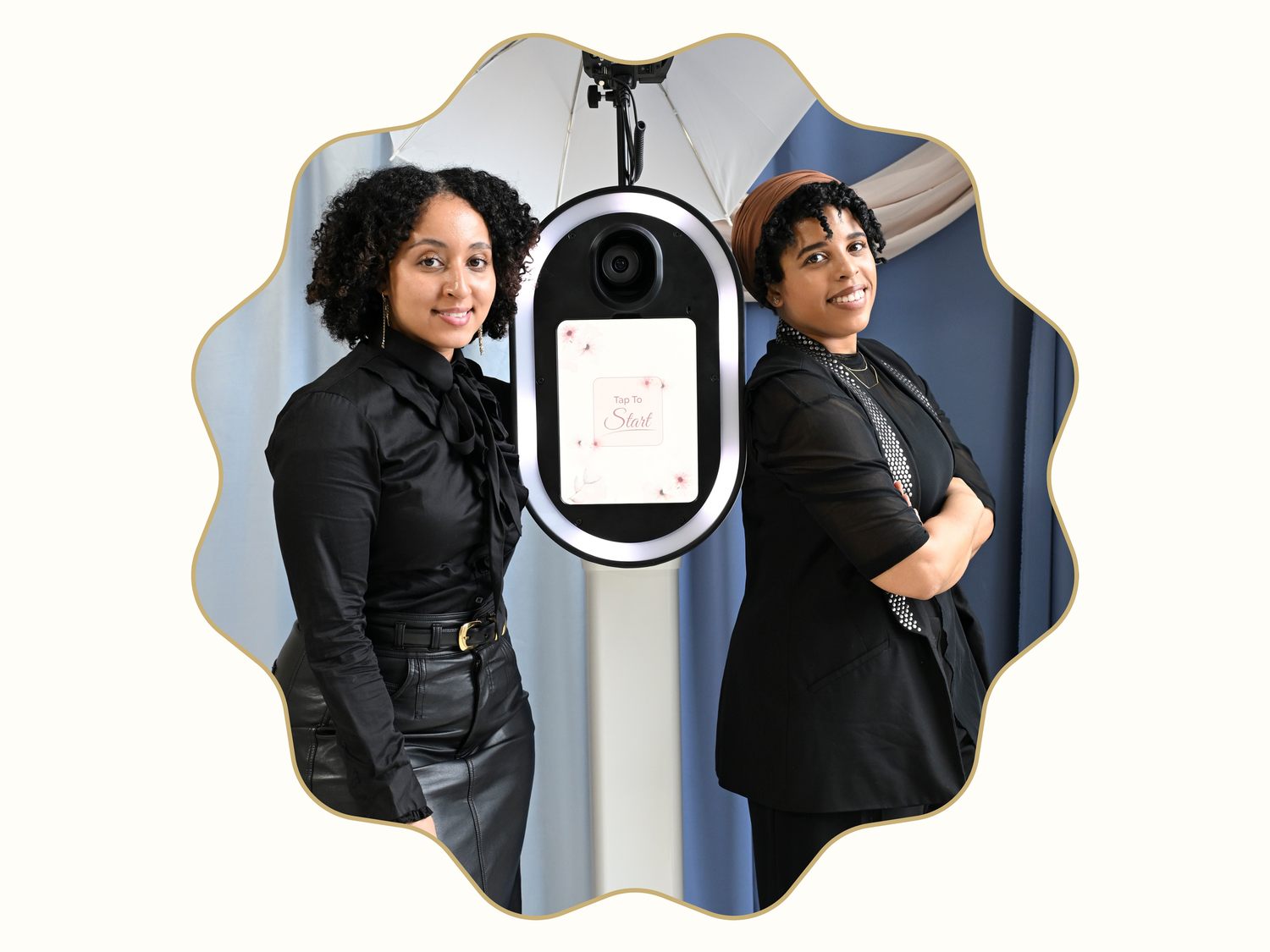 Two people in black outfits posing on either side of a digital display device.