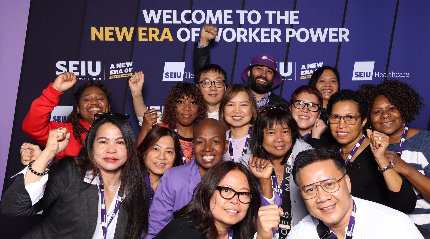 Large group of SEIU union members gathered at a conference with welcome banner and purple branding.