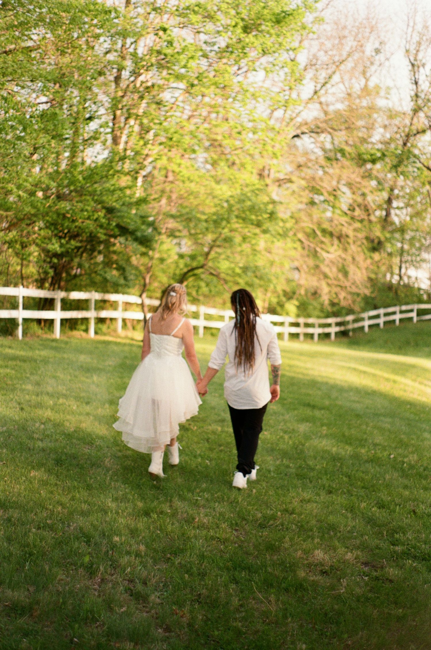 A film photo of a couple walking hand in hand on their wedding day in Adel, Iowa.