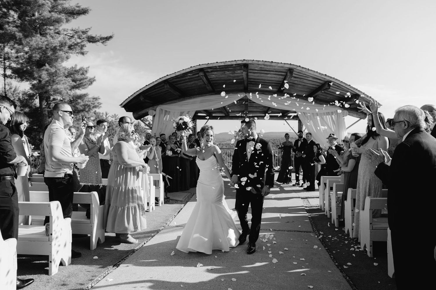 Joyful wedding procession with a petal throw by Veronique Jones. Capturing authentic, iconic moments with a documentary-luxe lens.