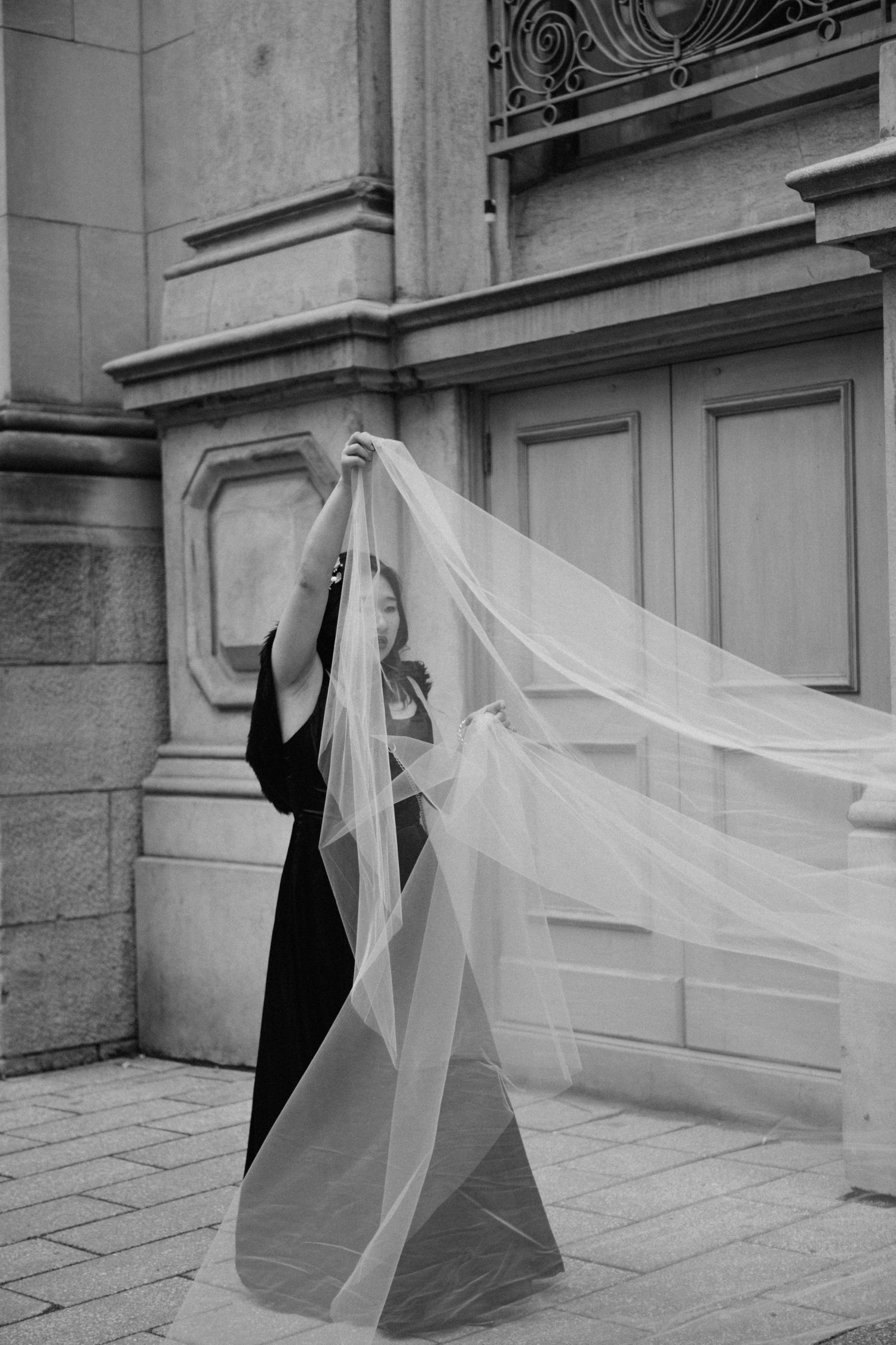 Candid, documentary style photo of bridesmaid holding bride's veil, by Veronique Jones, Montreal wedding photographer
