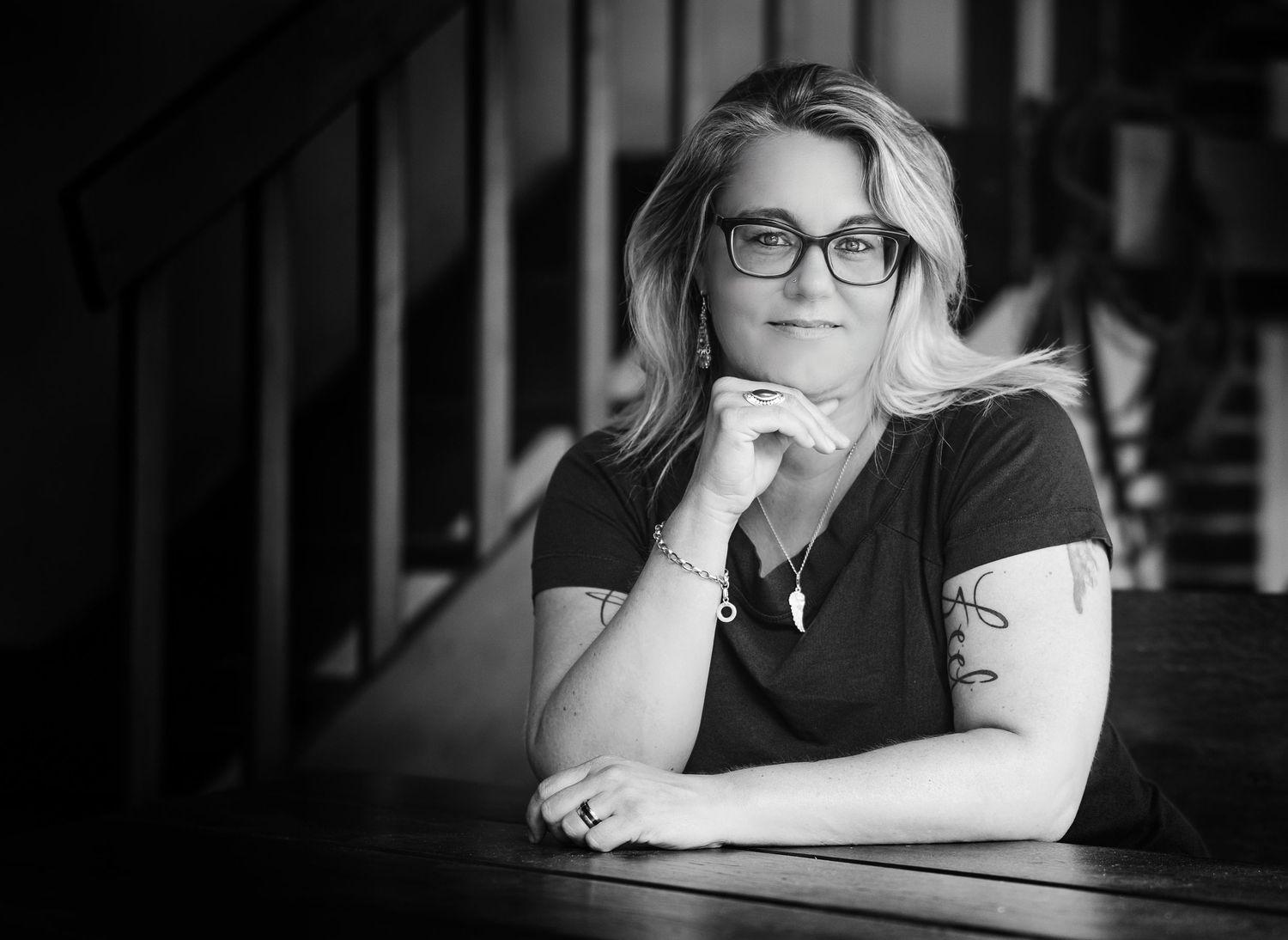 A black and white photo series showing someone in glasses sitting at a desk in contemplative poses.
