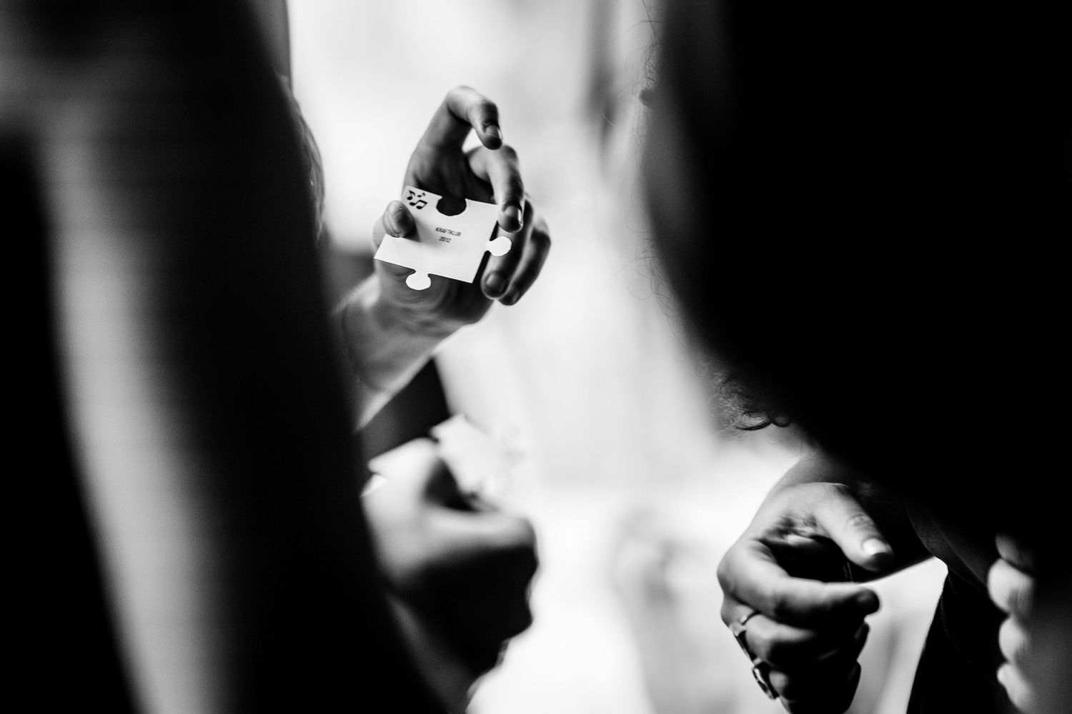 Close-up black and white detail shot of hands applying perfume to a bride before the wedding.