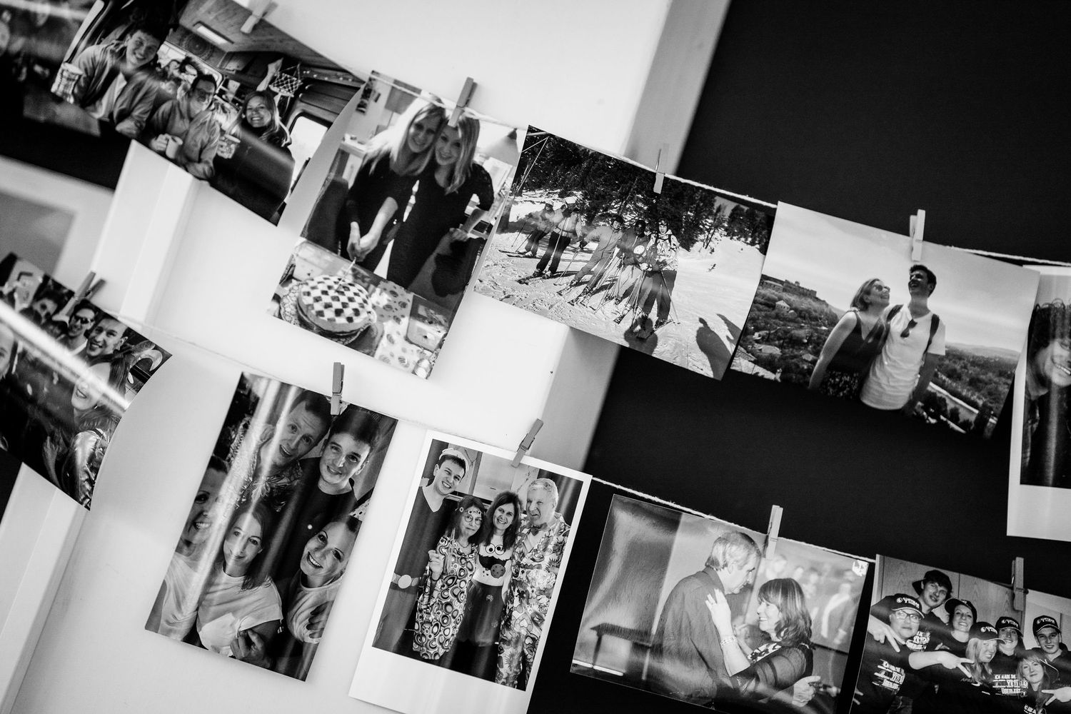 Black and white photo display of wedding memories hung with clothespins on string lines.