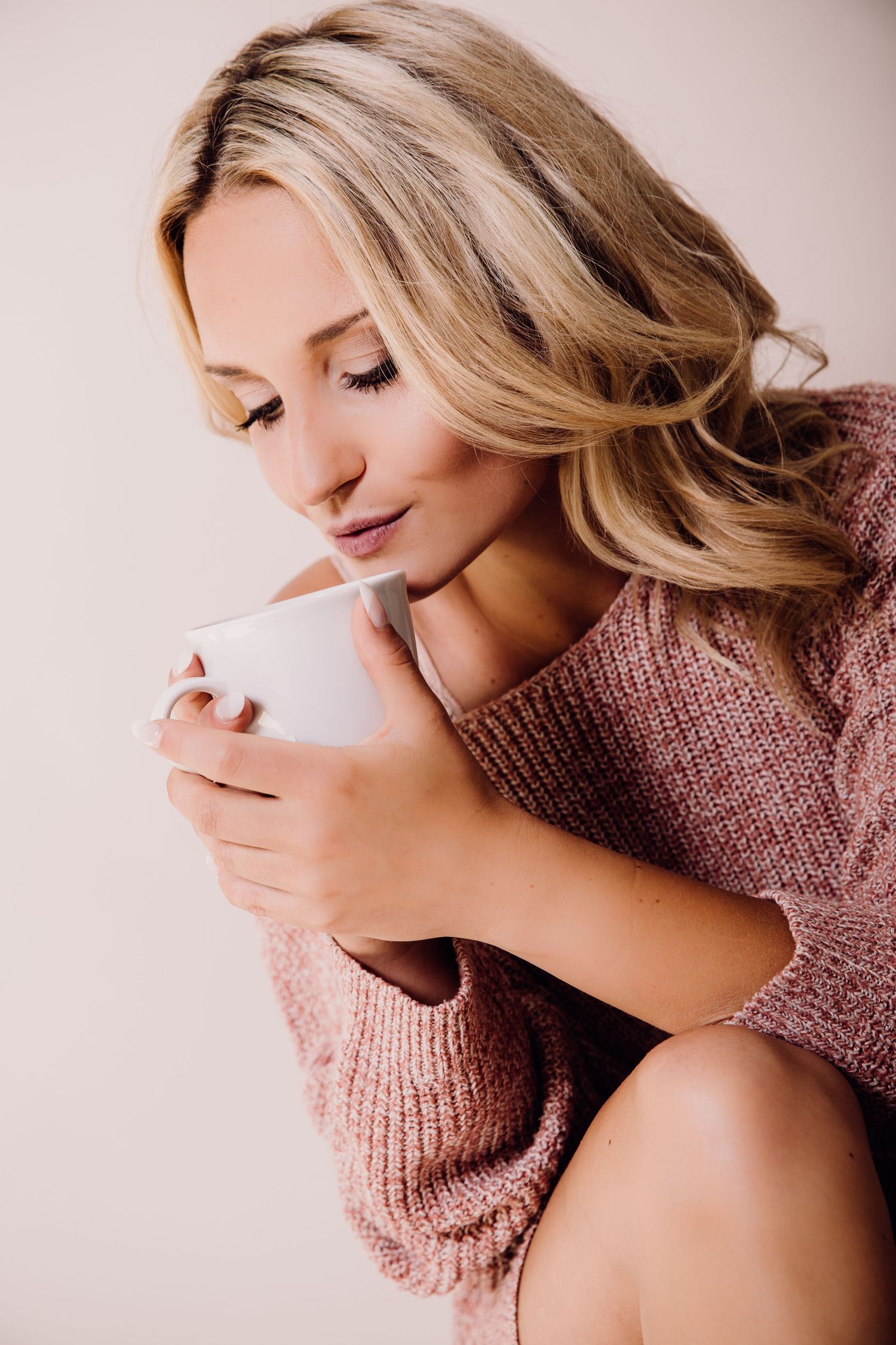 A series of artistic portrait photos showing someone in a pink knit sweater against a soft neutral background.