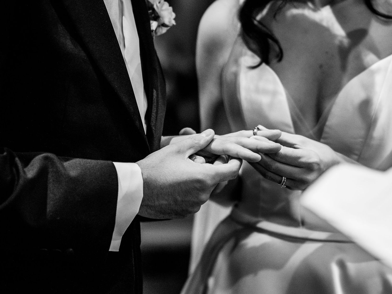 A black and white photo collage of hands exchanging wedding rings during a marriage ceremony.