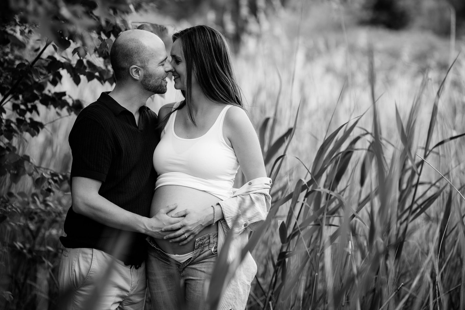 Black and white romantic couple portraits in a wheat field showing intimate moments and tender embraces.