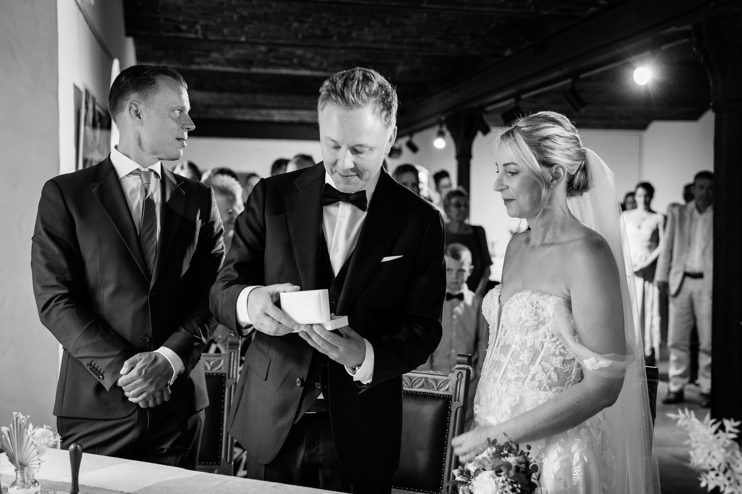 Groom reading vows during elegant black and white indoor wedding ceremony.