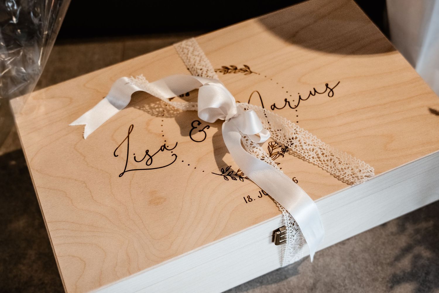 Elegant wooden keepsake box engraved with Lisa and Marius tied with a white ribbon bow.