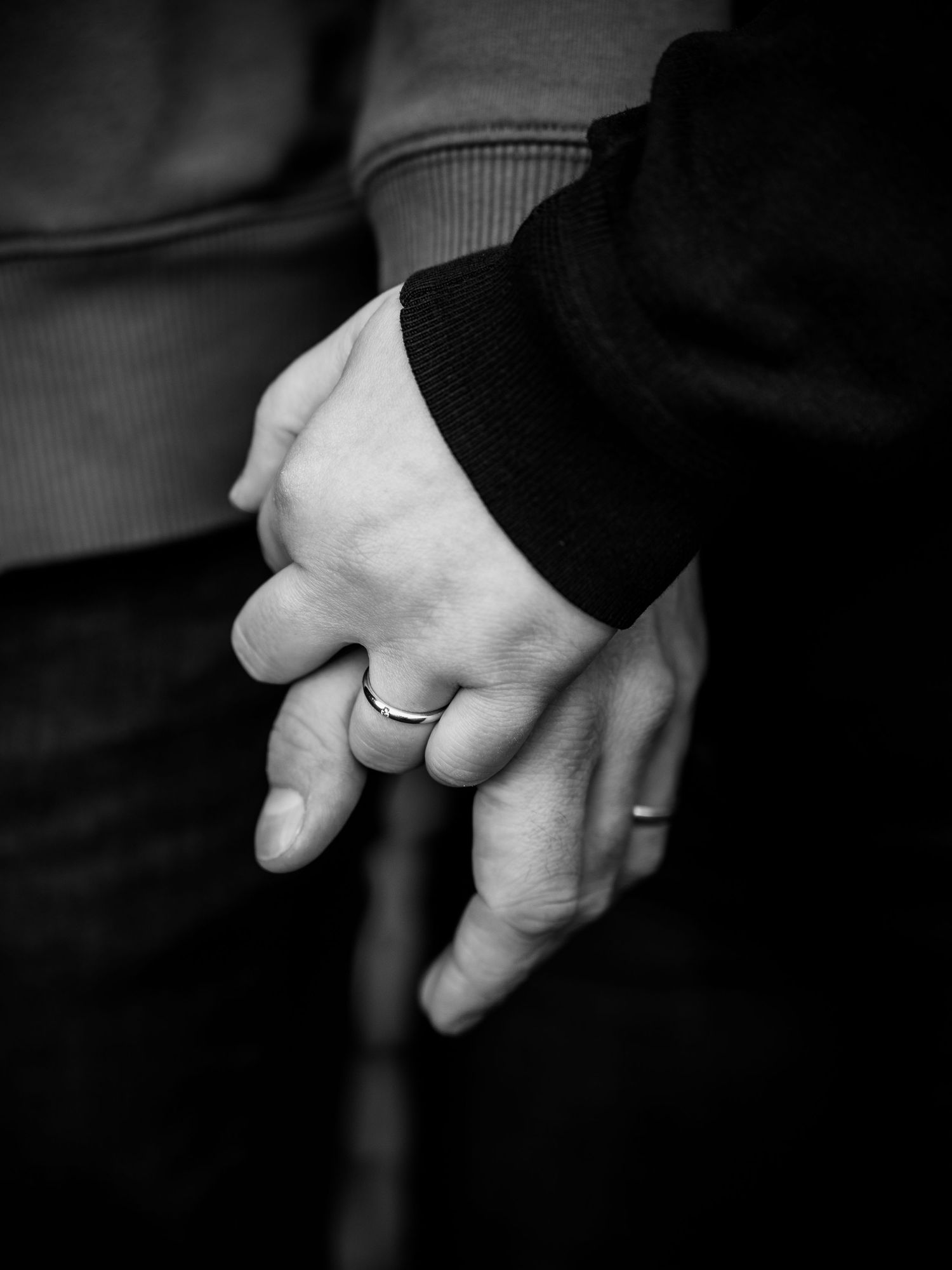 A series of black and white photographs showing hands with wedding rings held together in intimate poses.
