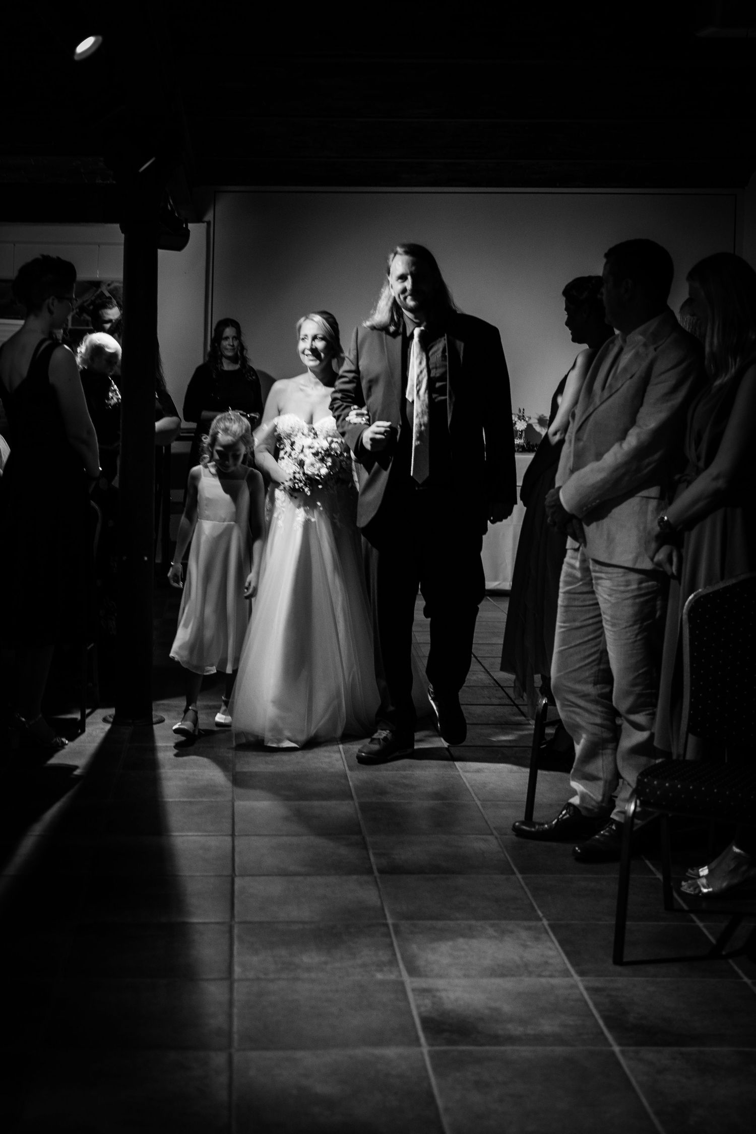 Black and white photo of a bride and groom walking down the aisle at their wedding ceremony.