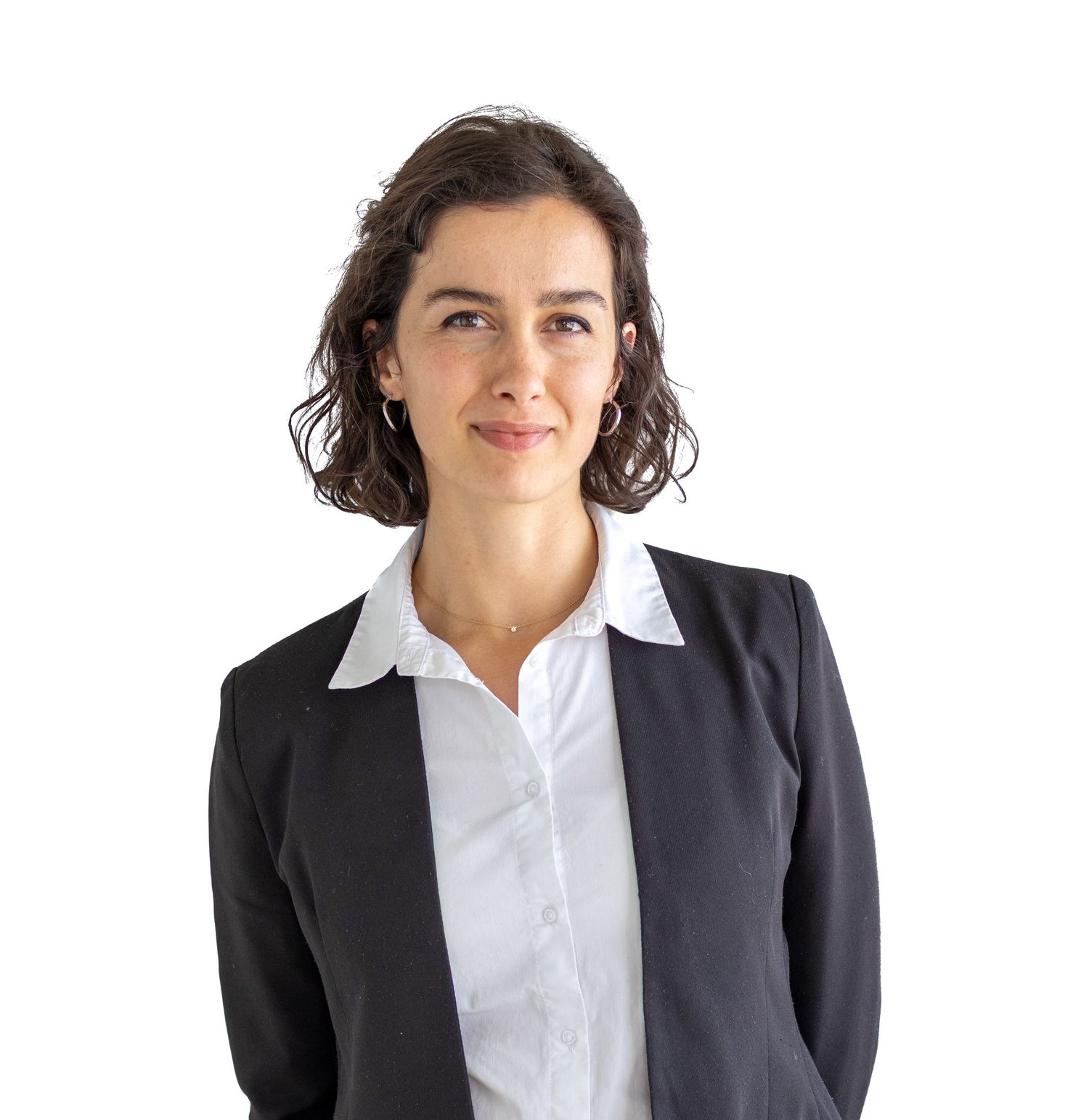 Professional woman in black blazer and white shirt smiling confidently against white background.