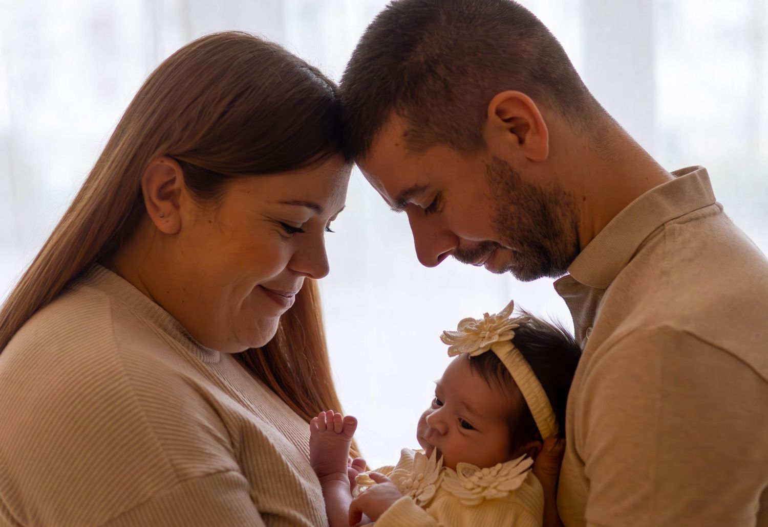 parents avec leur bébé lors d'une séance naissance naturelle dans le studio à L'Arbresle ( ouest lyonnais) en lumière douce.
