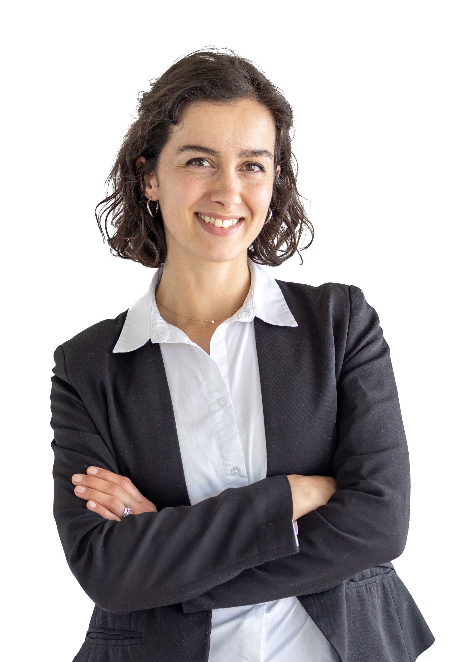 Professional businesswoman in dark blazer smiling with arms crossed against white background.
