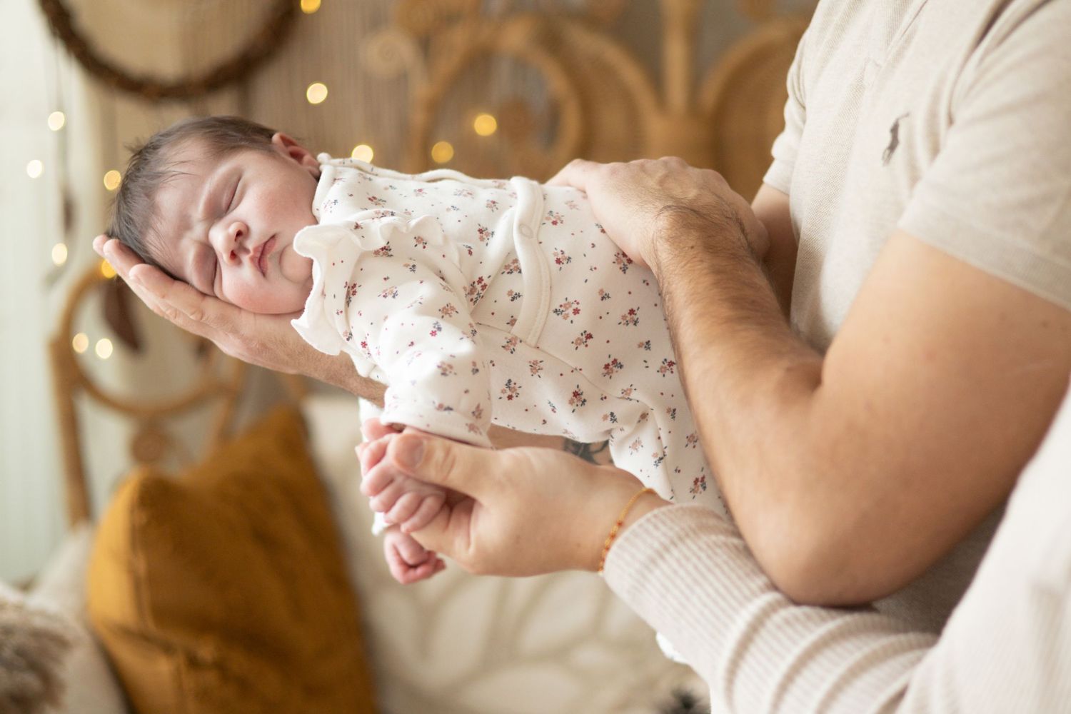 bébé allongé dans les bras de ses parents, séance naissance naturelle dans le studio à L'Arbresle ( ouest lyonnais)