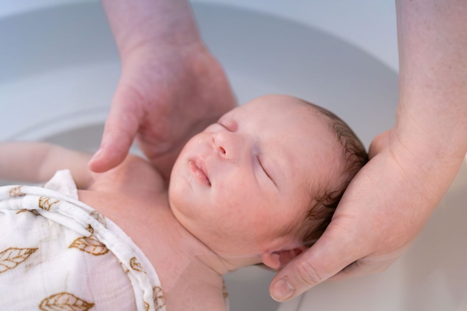 Bébé lors d'un bain enveloppé à Lentilly . Moment apaisant.
